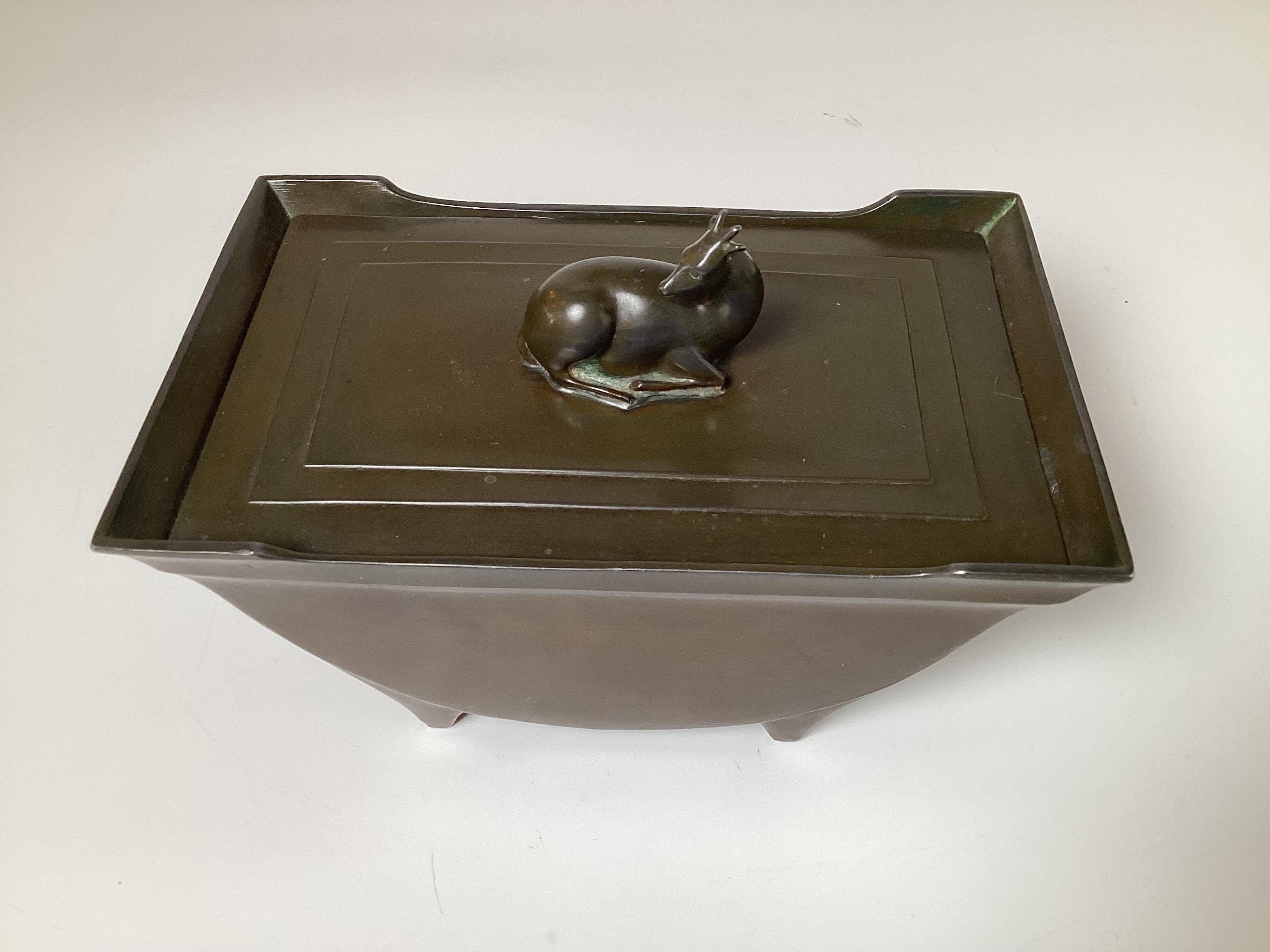 Eine Art-Deco-Box aus patinierter Bronze von Disko Metal, Dänemark,  Auf dem Deckel ist ein Rehkitz abgebildet, das auf einem Sockel mit Fuß ruht.  7 Zoll breit, 4,75 Zoll hoch, 4,5 Zoll tief 