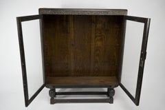 An Art Deco dark and limed oak glazed bookcase with carved floral decoration.