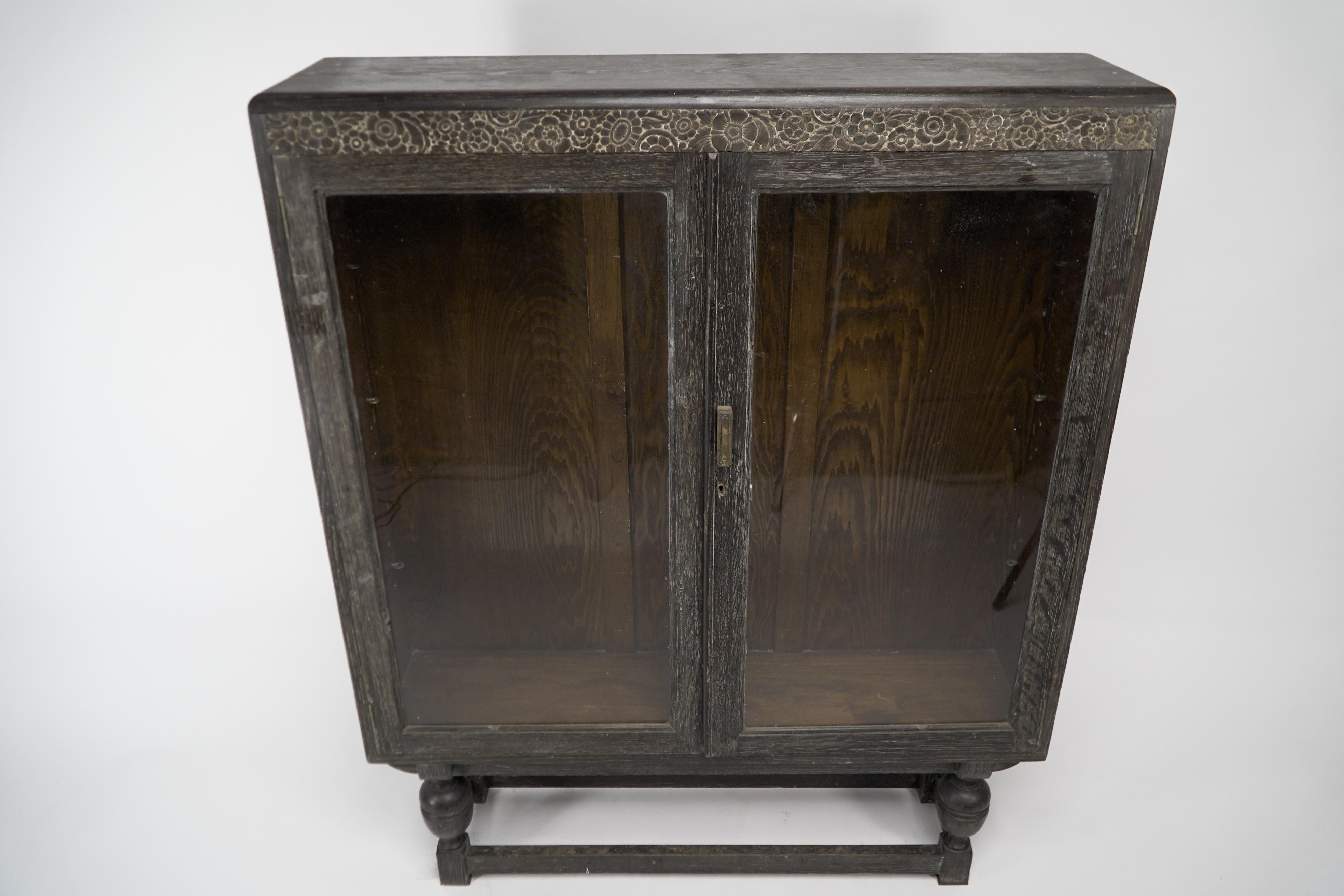 English An Art Deco dark and limed oak glazed bookcase with carved floral decoration. For Sale