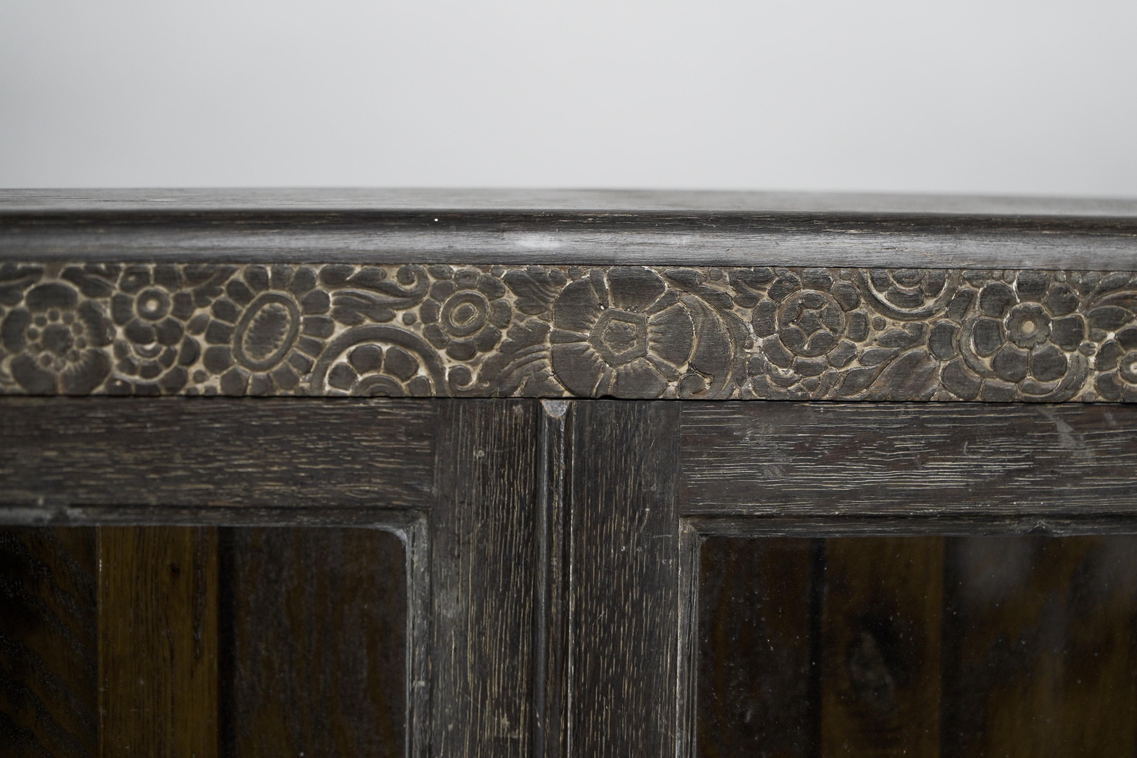 An Art Deco dark and limed oak glazed bookcase with carved floral decoration. For Sale 1