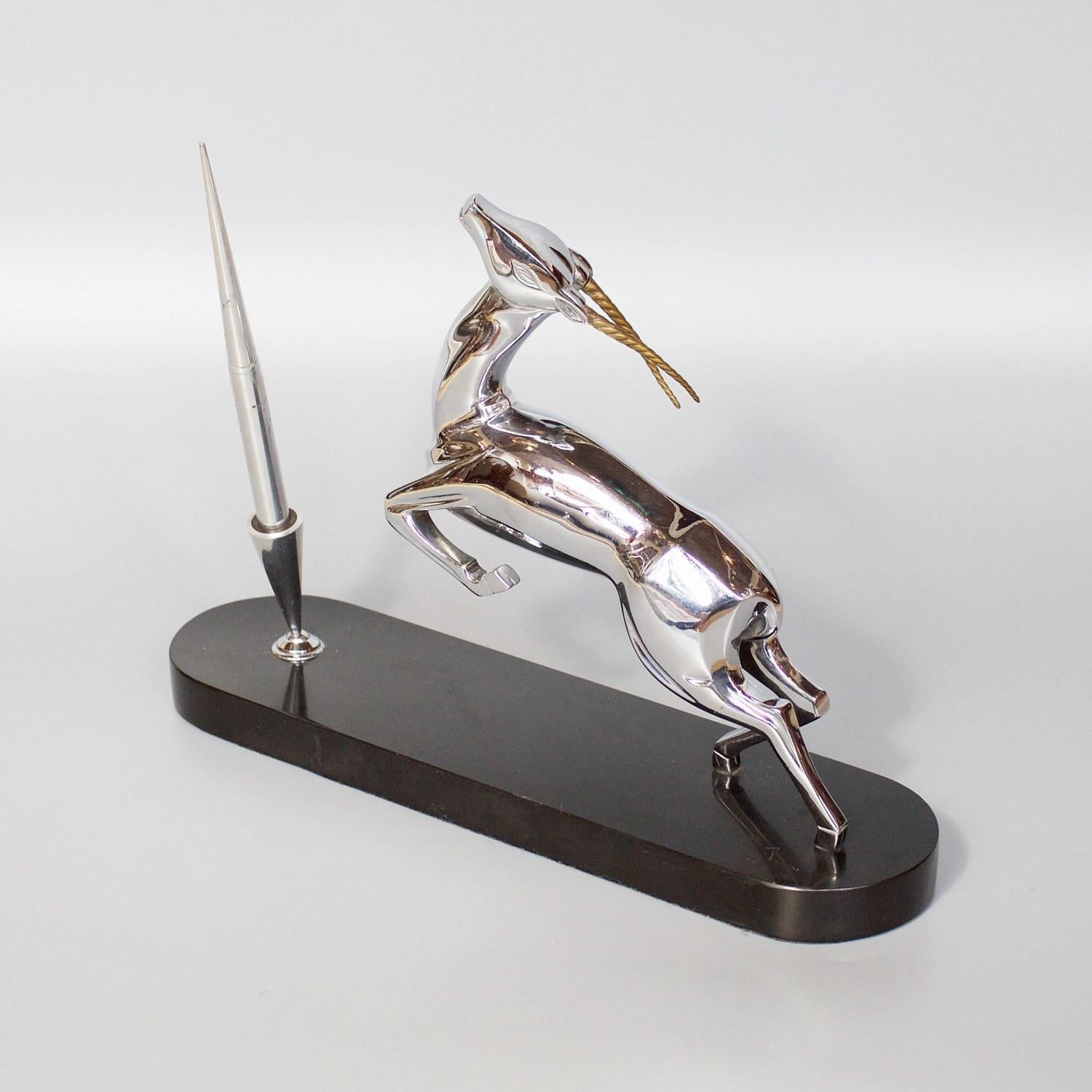 An Art Deco fountain pen and holder with a silvered bronze Gazelle in motion. Set over a black marble base. 

Dimensions: H 22.5cm, L 31cm, W 8cm 

Origin: English

Date: circa 1930

Item number: 2601215.