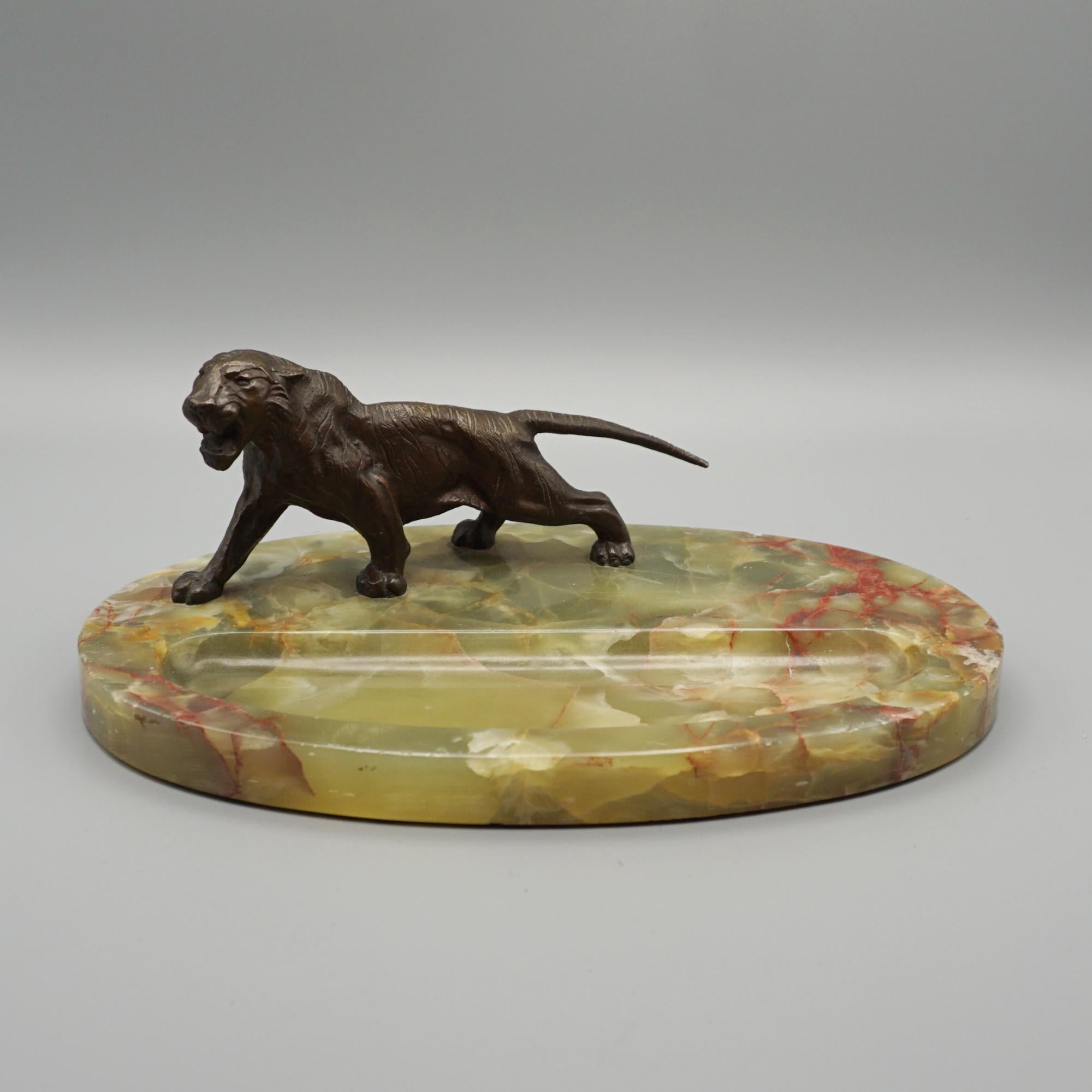 An Art Deco Desk Tidy/ Pin Tray. Bronze tiger mounted ob an oval onyx base. Retailed by Asprey of London 

Dimensions: H 8cm W 16.5cm D 25cm 

Origin: English 

Date: Circa 1925 

Item Number: 1804243