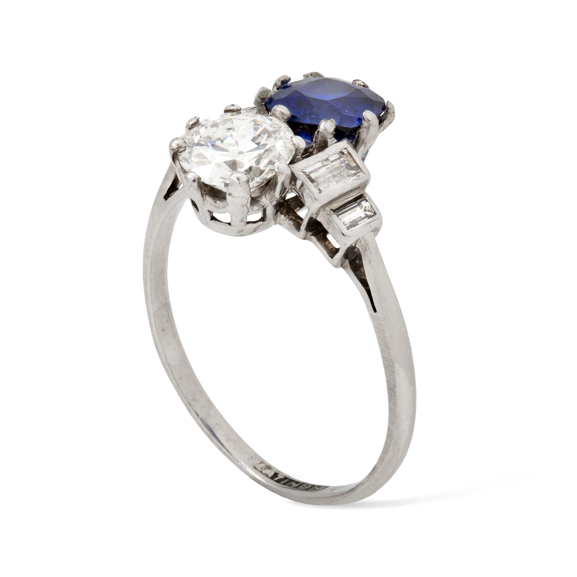 An Art Deco diamond and sapphire ring, the old brilliant-cut diamond weighing approximately 0.8 carats and the cushion-cut sapphire estimated to weigh 0.9 carats, claw-set vertically to a platinum mount between baguette diamond-set shoulders,  circa