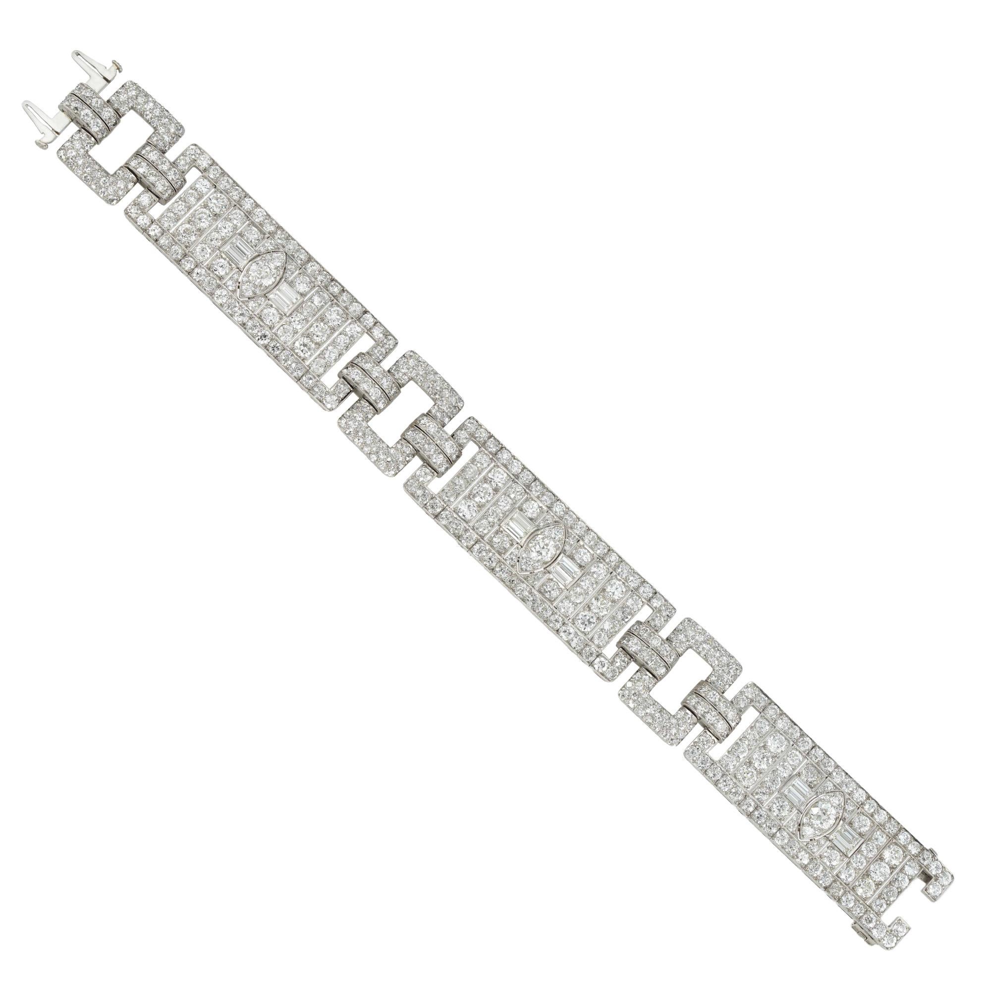 Un bracelet Art-Déco en diamants de Raymond Yard, composé de trois panneaux flexibles de conception géométrique et sertis de diamants de taille ancienne et baguette, reliés à trois maillons rectangulaires percés sertis de petits diamants de taille