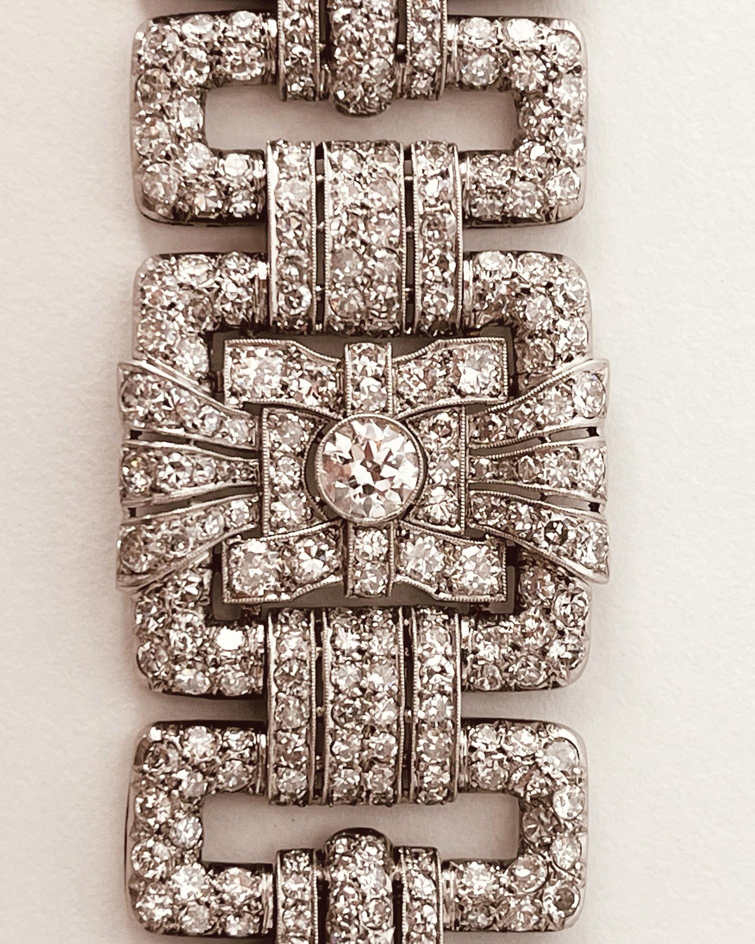 An Art Deco diamond bracelet. Set throughout with brilliant and circular-cut diamonds. The largest diamonds estimated to weigh 1ct each. Total diamond weight approximately 25cts. French marks. Circa 1935. 19cm in length and approximately 3.1cm wide.