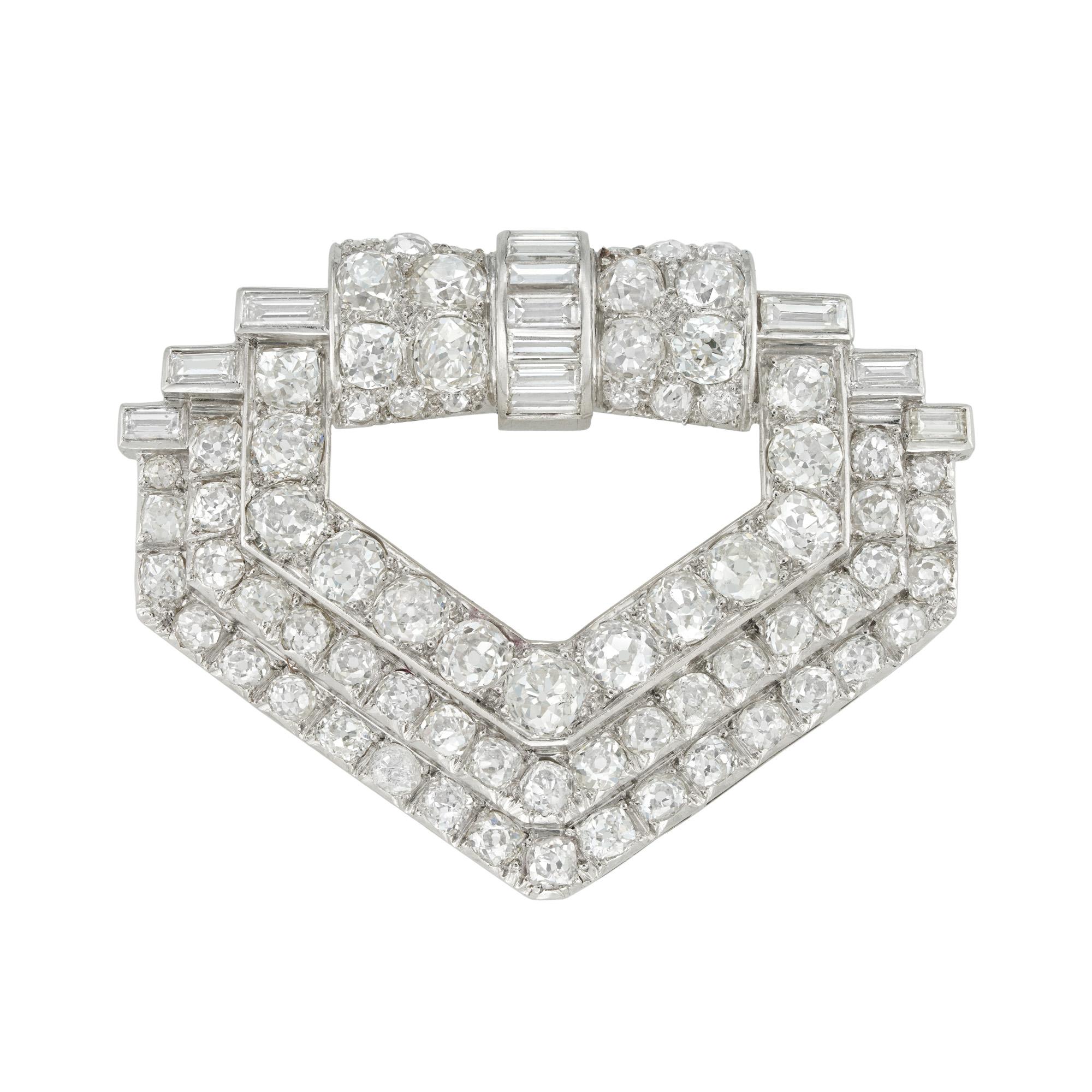 An Art Deco diamond brooch, set with baguette and old European-cut diamonds estimated to weigh 15 carats in total, channel and grain-set in platinum mount of geometric design, with white gold double pin fitting, bearing French 18ct gold import