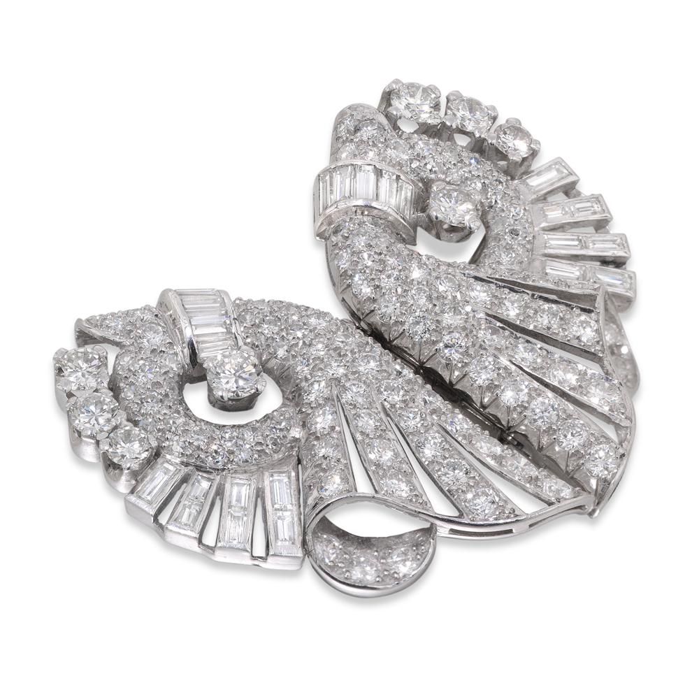 An Art Deco diamond set double-clip brooch, of a fluted scrolled fan design, set with baguette-cut and round brilliant-cut diamonds, the baguette-cut diamonds all in channel settings, the round brilliant-cut diamonds in a mixture of pavé and claw