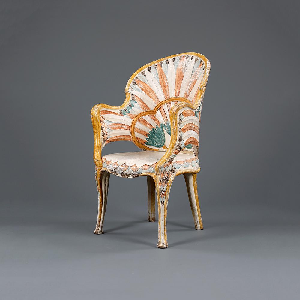 An Art Deco Egyptian Revival chair, the back-rest and arms elegantly carved and painted with stylized lotus leaves and the seat with fish-scales.