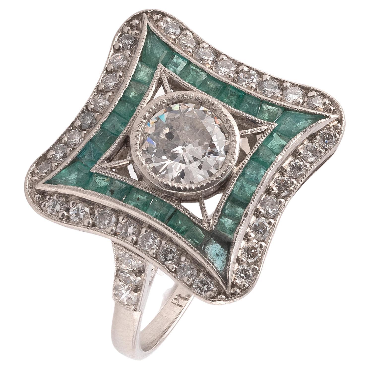 The rectangular plaque set at the centre with an old brilliant-cut diamond approximately 1,2ct, within a geometric frame of smaller similarly cut diamonds and calibré-cut emeralds , finger size 7 1/2
Weight: 5,36gr.