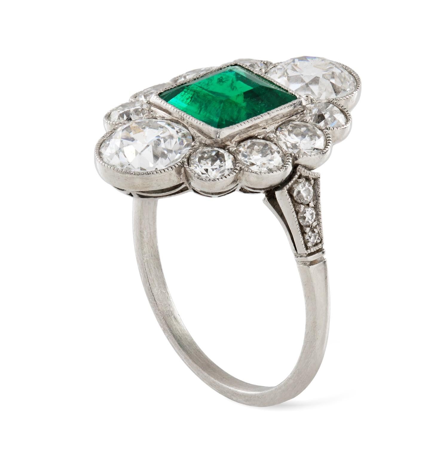 An Art Deco emerald and diamond ring, the square-cut emerald estimated to weigh 1.7 carats, accompanied by GCS Report stating to be of Colombian origin, vertically-set between two old European-cut diamonds each estimated to weigh approximately 1