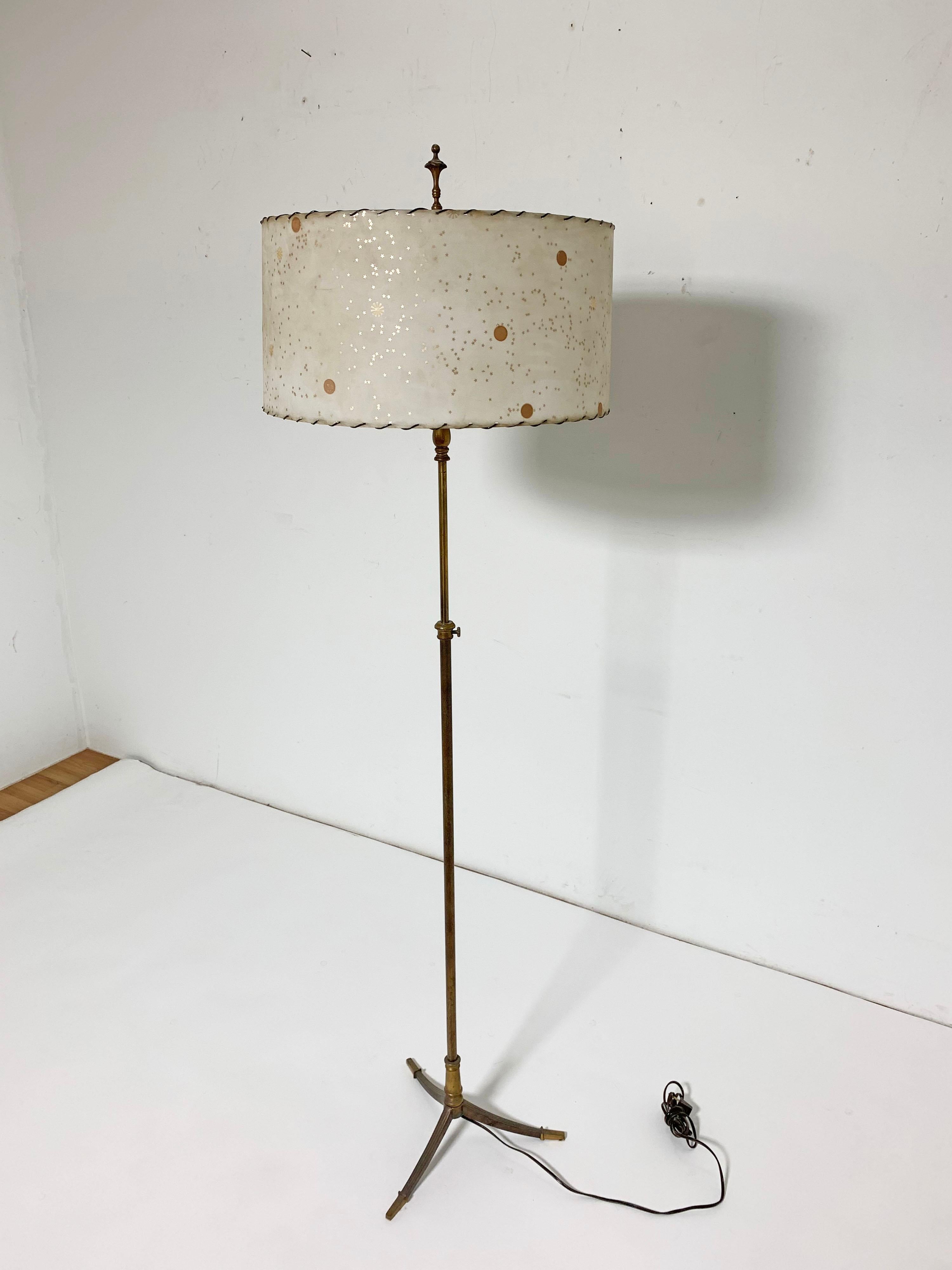 An adjustable height bronze floor lamp with tripod base and parchment shade, circa 1930s.
Measures: 65.5