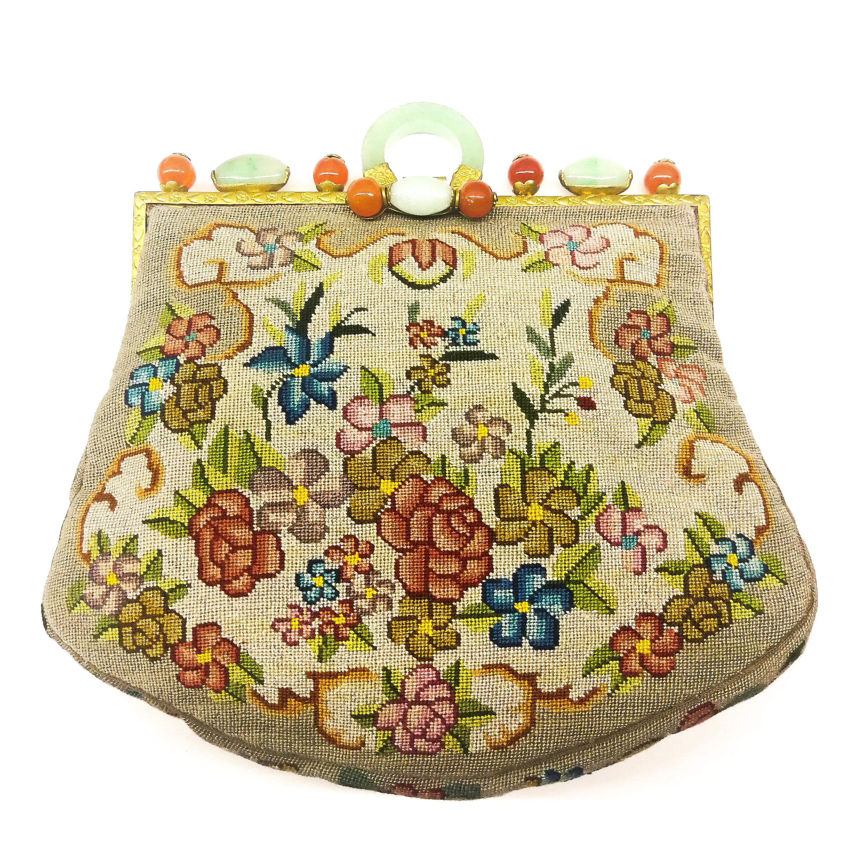 An utterly charming and striking clutch bag from the 1920s. The bag is in fine 'petitpoint' with stylised Art Deco floral motifs on both sides, in an assortment of colours , all on a soft oyster brown background. The frame is decorated with round