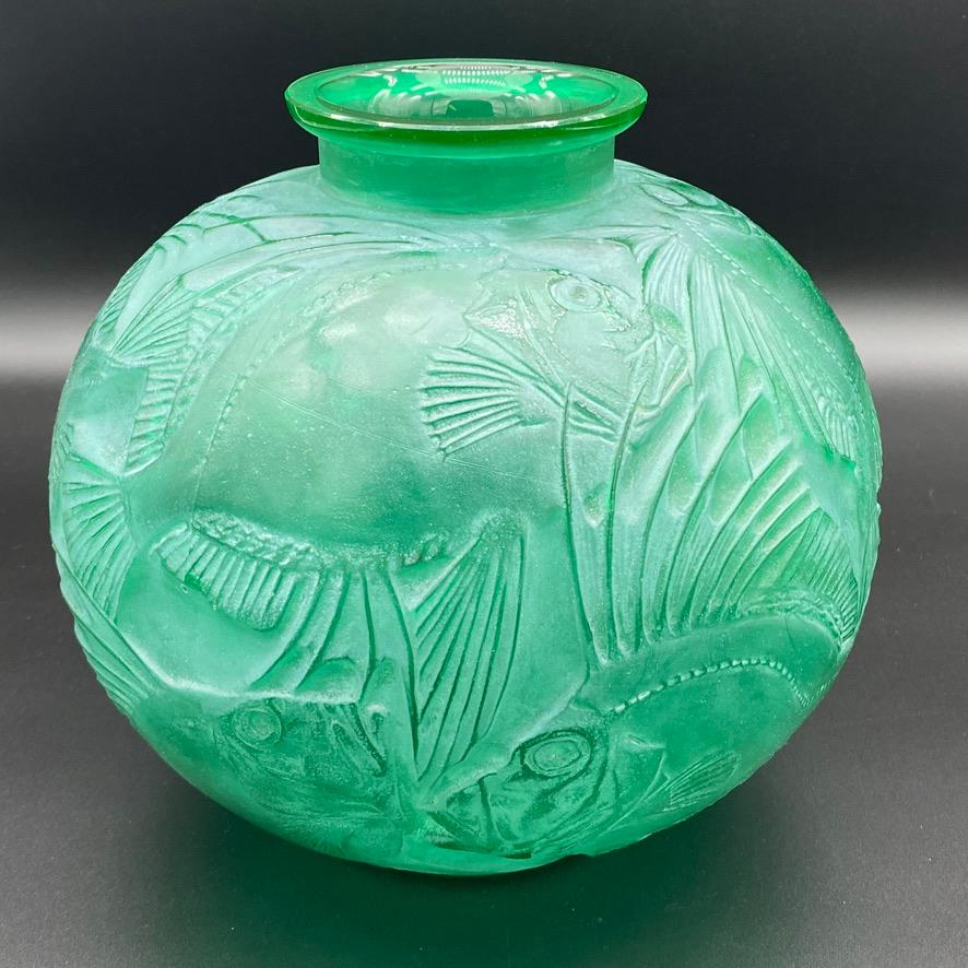 The Poisson vase is one of the most well known vases of R.lalique .

The design is strongly Art Deco and the large fishes swim all around the vase's body.

The vase was made in 1922 in white glass by R.Lalique .

This green glass and white patinated