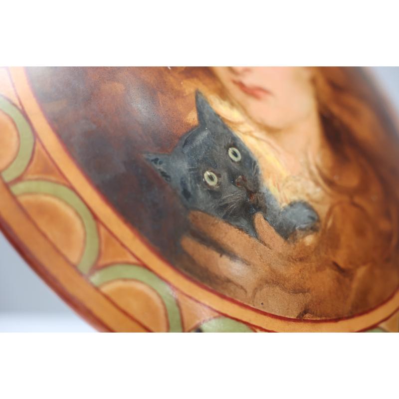 An Art Deco hand painted plate depicting Lois the Witch holding a black cat. 1