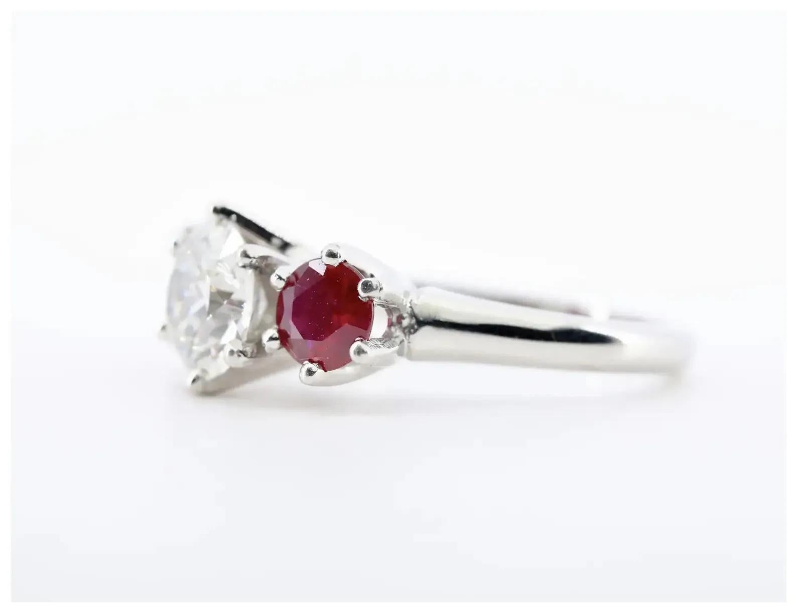 A beautiful Edwardian period three stone diamond, and ruby engagement ring in platinum.

Centered by a 1.18 carat H color I1 clarity old European cut diamond.

Framed by a pair of 1.00ctw rubies of beautiful vivid red color.

Tested as