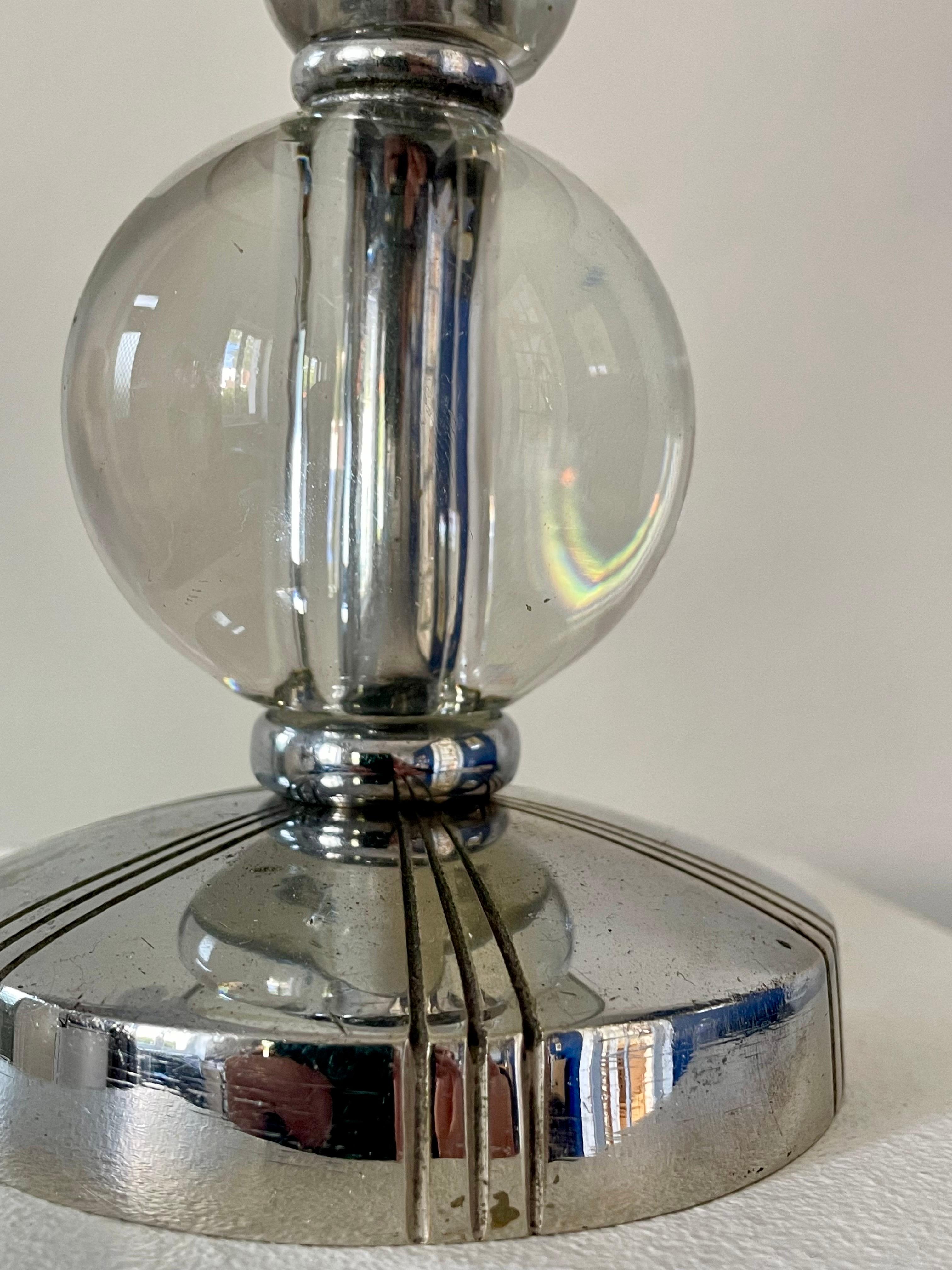 An elegant and timeless Art Deco lamp inspired by the renowned designer Jacques Adnet. Perfect for adding a touch of sophistication to any interior, this lamp seamlessly combines luxurious materials such as copper-plated brass and glass spheres with