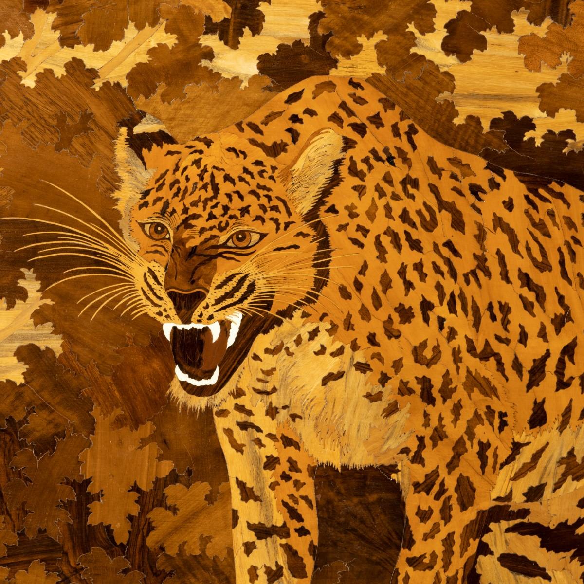 Panneau de marqueterie Art déco représentant un jaguar, de forme rectangulaire représentant un jaguar hargneux émergeant d'un bois, travaillé dans des bois exotiques dont le noyer, le bois de roi, le bois de satin et l'ivoire sur un fond de buis, le