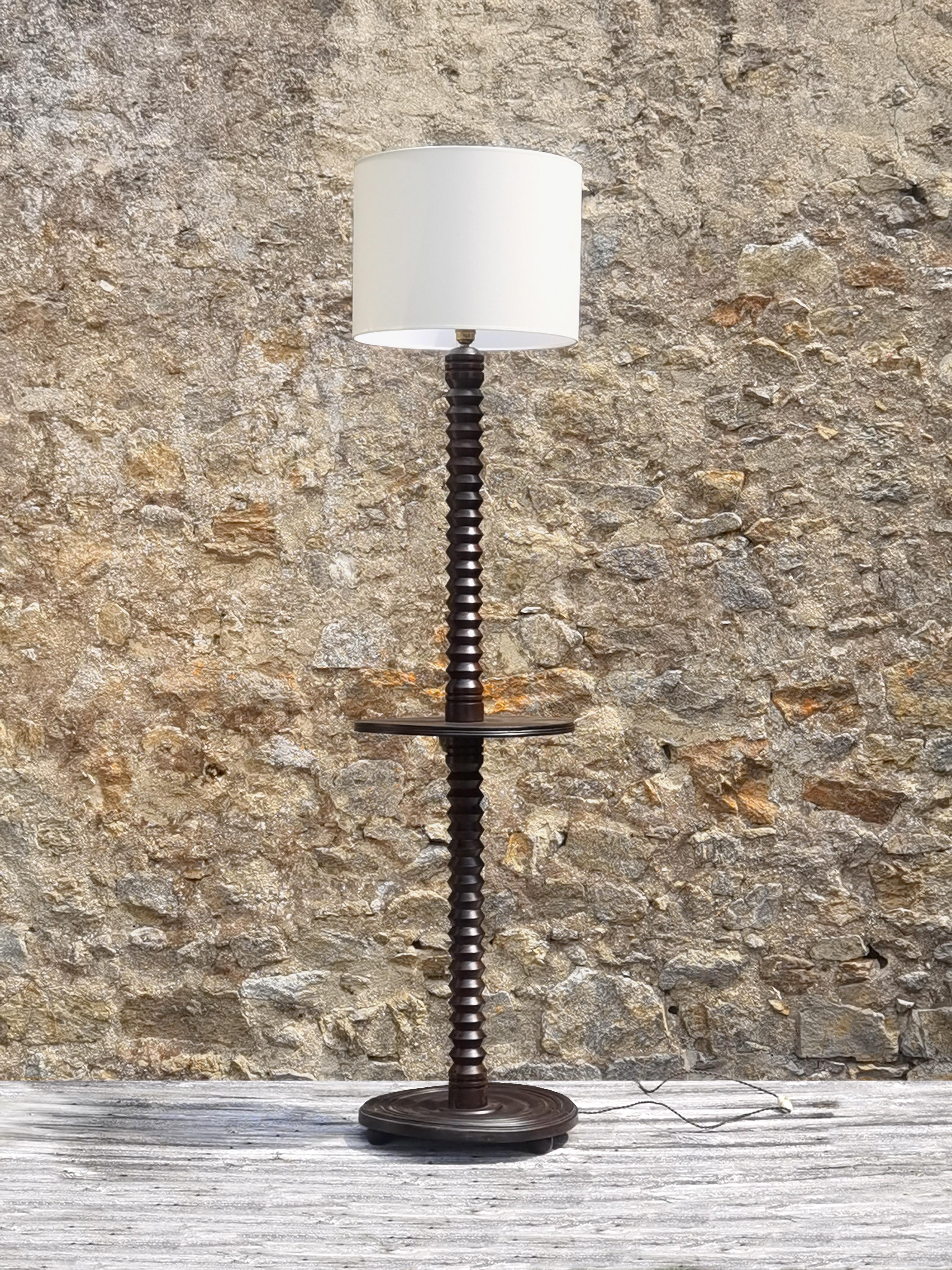 A thin and elegant floor lamp, Art-Deco, Modernist, Cubist, Constructivist, Machine-Age, massive wood circular base mounted on 3 wooden spheres in a Machine-Age manner, thin and very graphic vertical axis remembering an oversized mechanical screw in