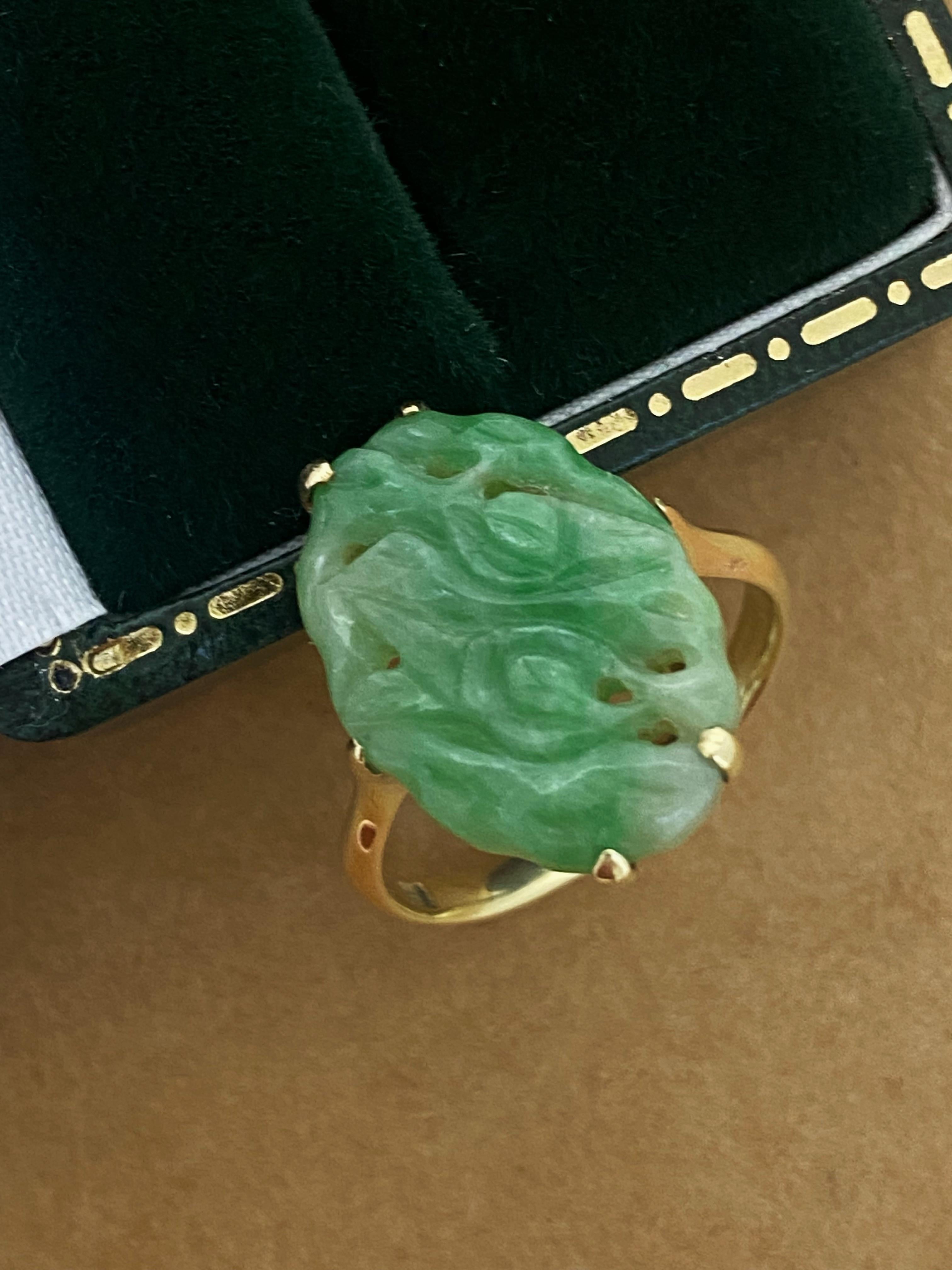 This Art-Deco c1930’s ring is in beautiful condition

Set with an oval intricately carved (in floral motif) & pierced
Natural Green Jade, measuring 19mm x 13mm 
of distinctive apple green colour 
(one of the best colours for a jade)
claw set in 14K