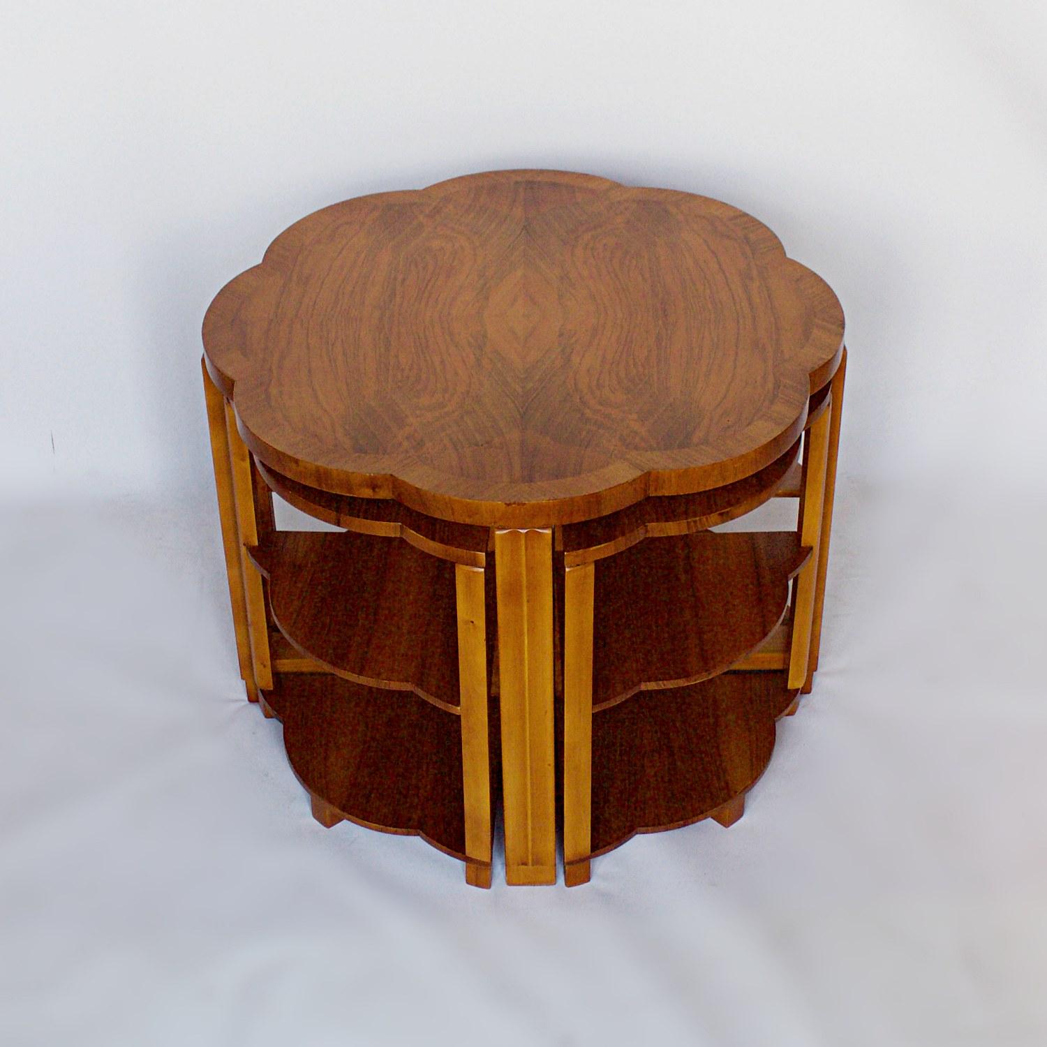 An Art Deco nest of tables by Harry & Lou Epstein. Burr walnut veneered, cloud shaped tabletop, with straight grain walnut banding and figured walnut legs. Four pullout / pull-out side table nests.

Dimensions: Table, H 56cm, W/D 74cm side tables,