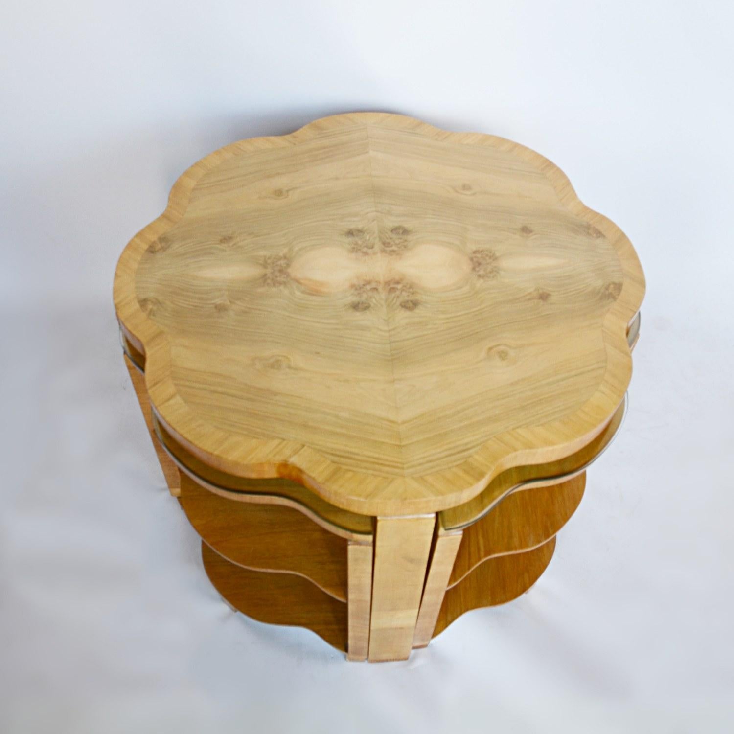 An Art Deco nest of tables by Harry & Lou Epstein. Burr walnut veneered cloud form table top with straight grain walnut banding. Four matching cloud form, straight grain walnut veneered pull out nests

Dimensions: H 55cm W 76cm D 76cm Nests: H