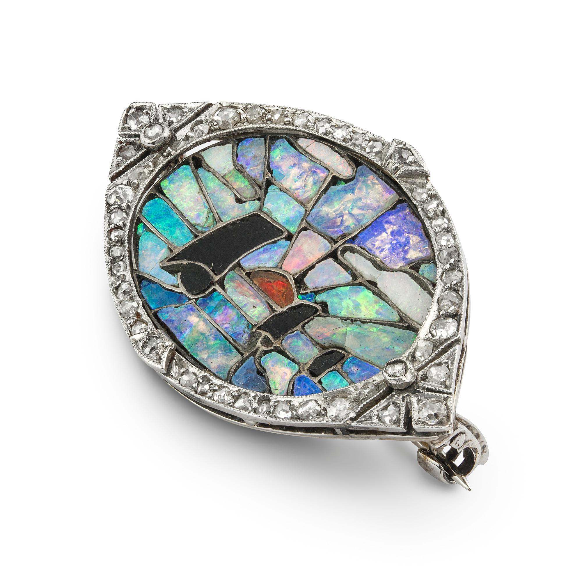 An Art Deco opal and onyx mosaic brooch, the oval panel a mosaic consisting of fire opal, black opal, and onyx, depicting three yachts at sunset, within a delicately scalloped border set with rose-cut diamonds, all set in platinum with gold back and