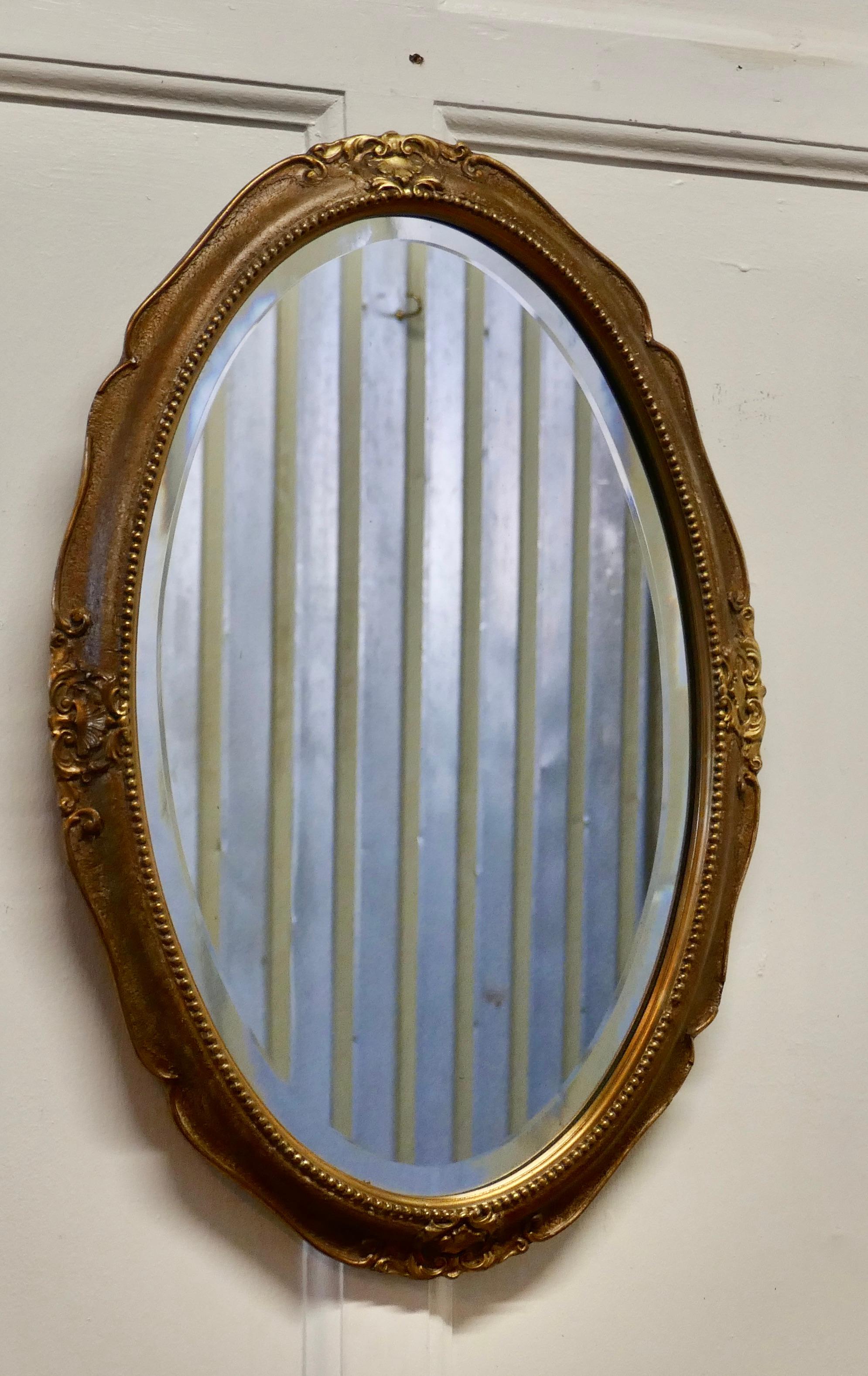 An Art Deco oval gilt wall mirror

The mirror has a very attractive 2” wide gilt Frame in a Rococo style decoration. 
This is a charming piece, with a bevelled glass, all in good condition 
The mirror is 16” wide and 24” tall,
AC144.
