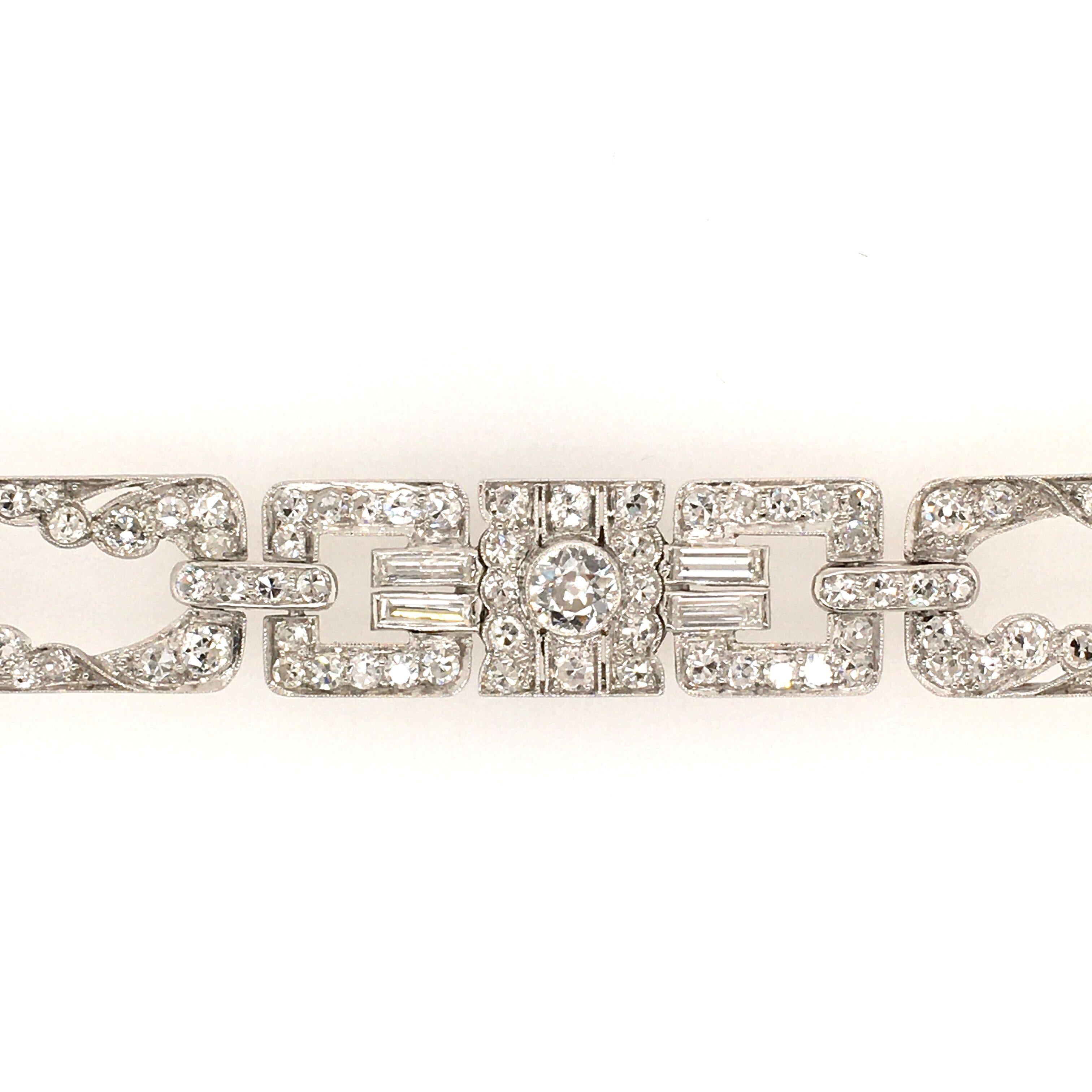 An Art Deco platinum and diamond bracelet.  Circa, 1930.  The bracelet is composed of three panels of geometric design set with the following:  1 Old European cut diamond weighing approximately .45 carat, 2 Old European cut diamonds each weighing