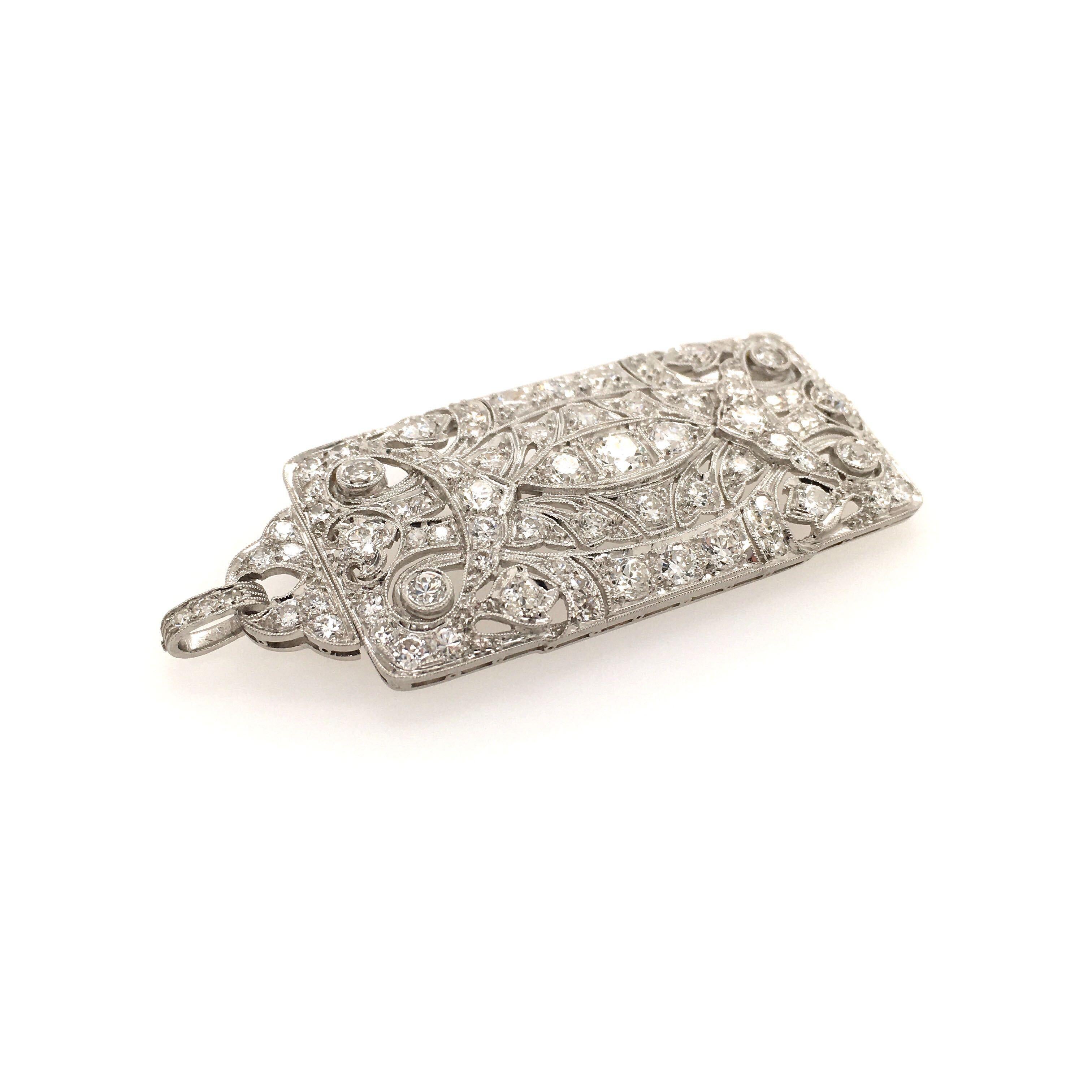 An Art Deco platinum and diamond pendant brooch. Circa 1925. Of rectangular outline, of pierced and openwork design, pave set with diamonds, with collapsible bale. The brooch measures approximately 2 inches with bale, gross weight is approximately