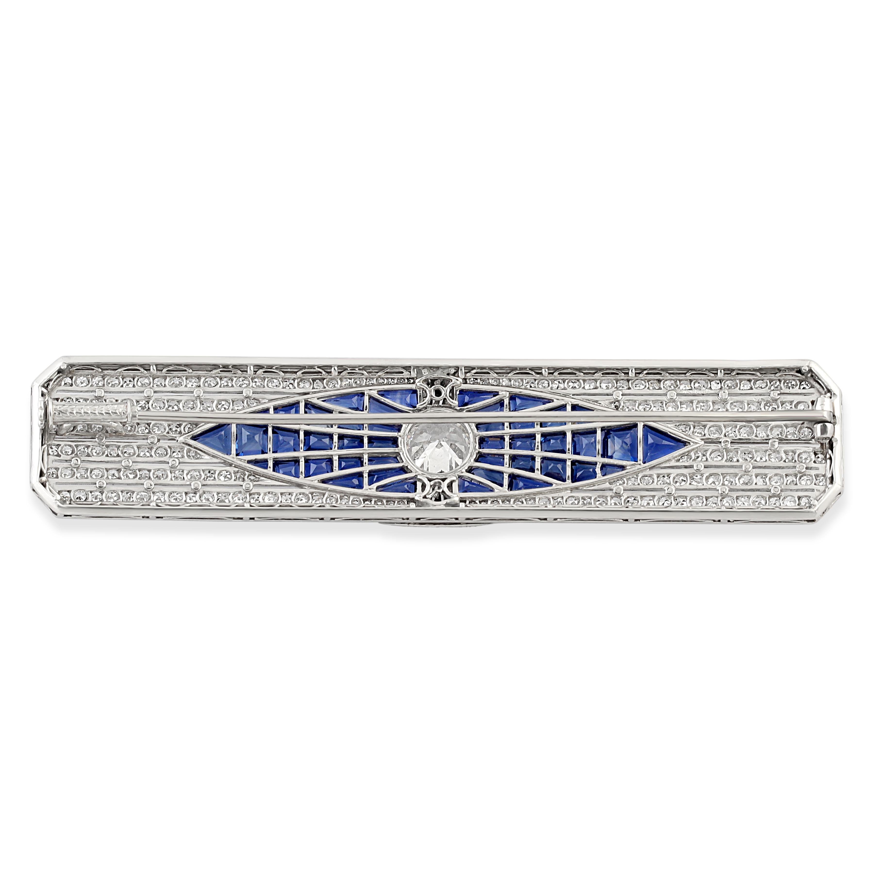 A striking Art Deco bar brooch crafted from platinum set with sapphires and diamonds. The centre stone = apx 1.90 carats surrounded by calibre-cut sapphires and diamonds in a classic geometric design. A fine example of Art Deco craftsmanship. 
