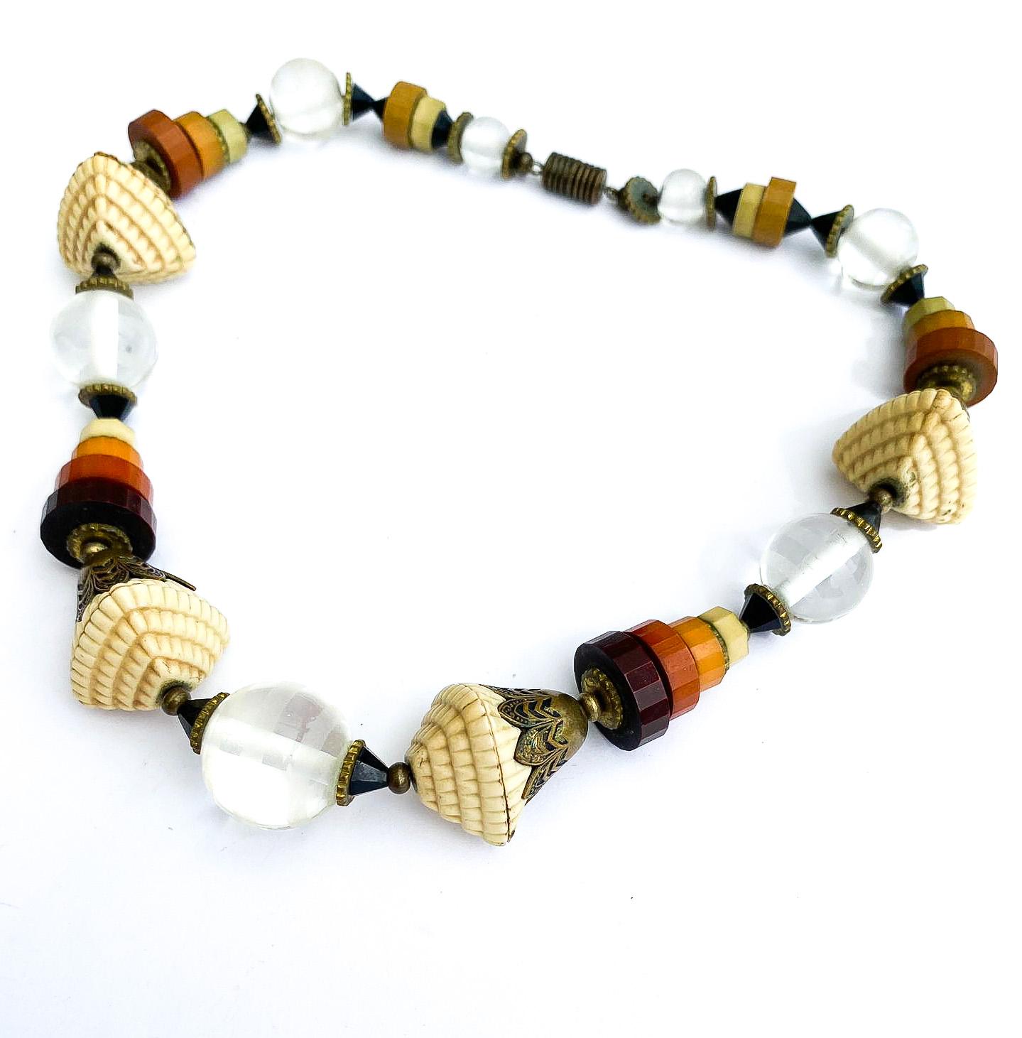 Collar de una sola fila, encantador y muy poco corriente, compuesto por cuentas y elementos de Galalith de colores, además de algunos elementos de celuloide moldeado, con cuentas de cristal transparente. Las cuentas escalonadas y las formas creadas