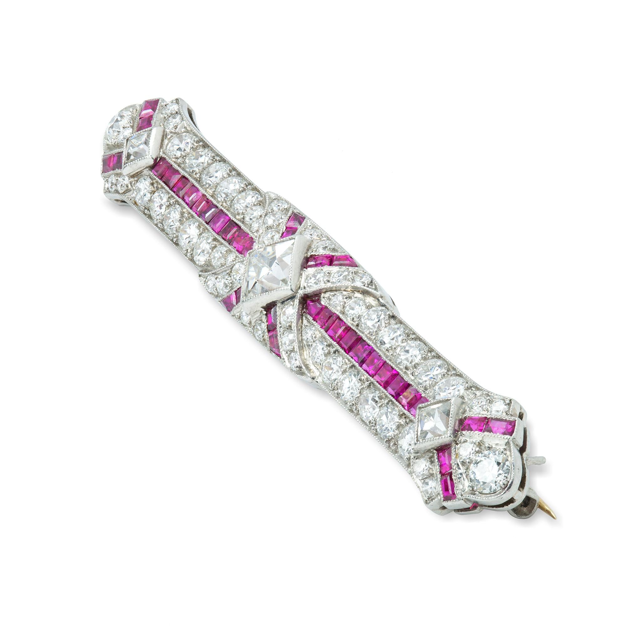 An Art Deco ruby and diamond bar brooch, the thirty-six calibre-cut rubies weighing approximately a total of 1.4 carats accompanied by GCS Report stating to be of Burmese origin with no indication of heat treatment, set with brilliant-cut and