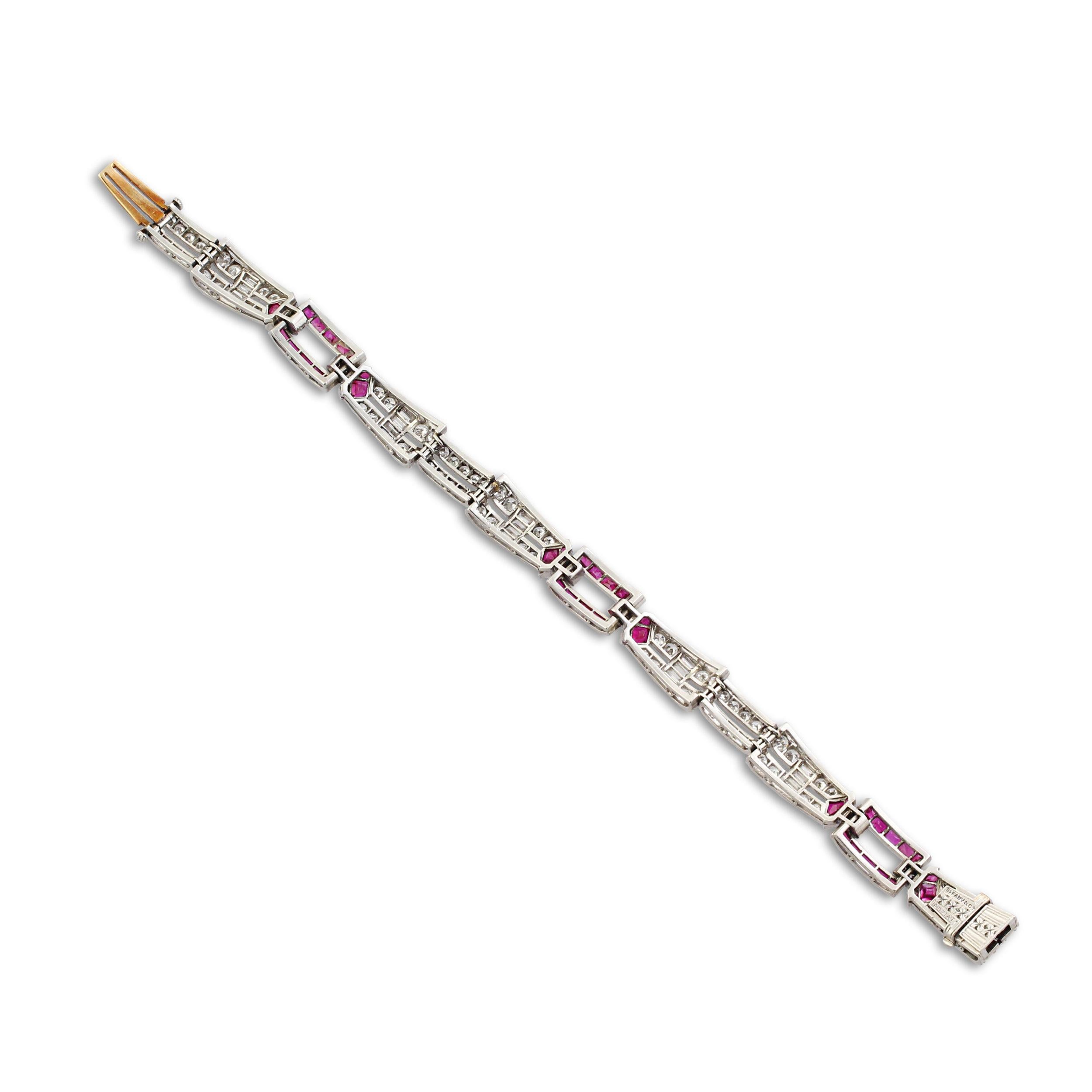 An elegant Art Deco platinum, ruby and diamond bracelet by Tiffany & Co. Set with calibre-cut rubies and round and baguette cut diamonds in an openwork geometric link design. Slim and slender, this beautiful bracelet can be easily stacked with