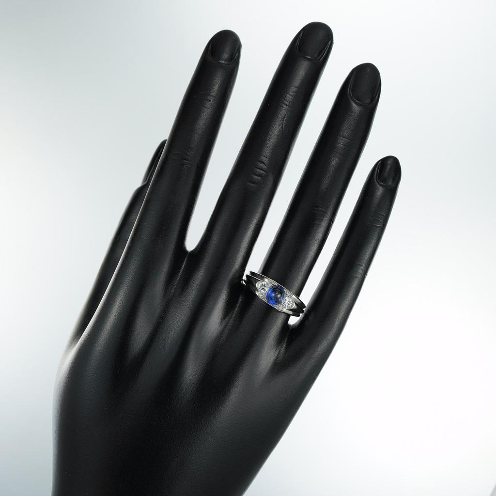 An Art Deco sapphire and diamond ring, the sugarloaf sapphire estimated to weigh ¾ of a carat, set with three old-brilliant-cut diamonds on each side estimated to weigh a combined total of ½  carat, the shoulders of rigged tapering design, mounted