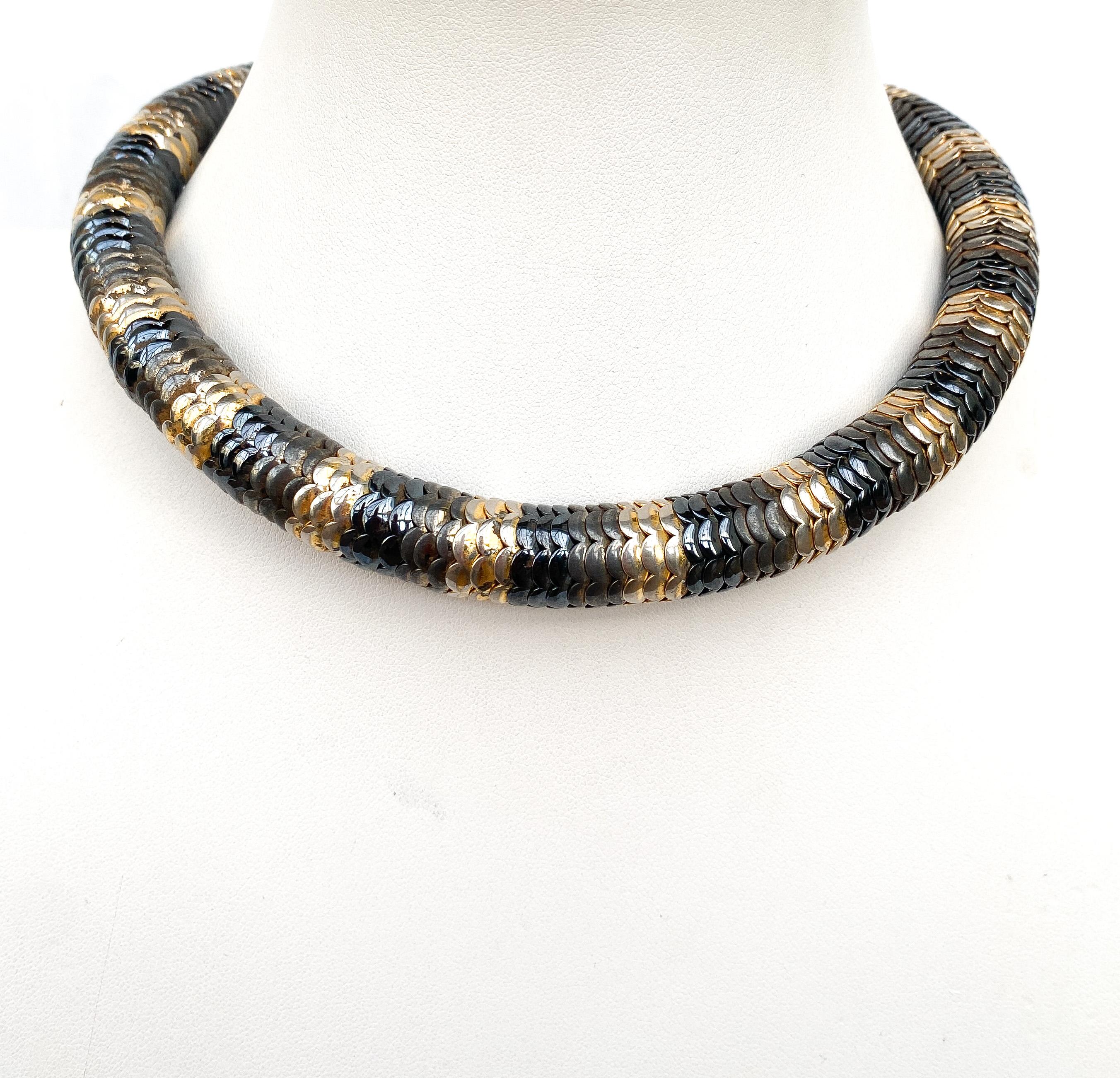 An unusual and very wearable Art Deco necklace, serpentine and very pliable, fitting to the wearer's neck.
Made from three colour metals, dark to light in tones, the necklace is composed of inter locking cones that create the flexible feel of this