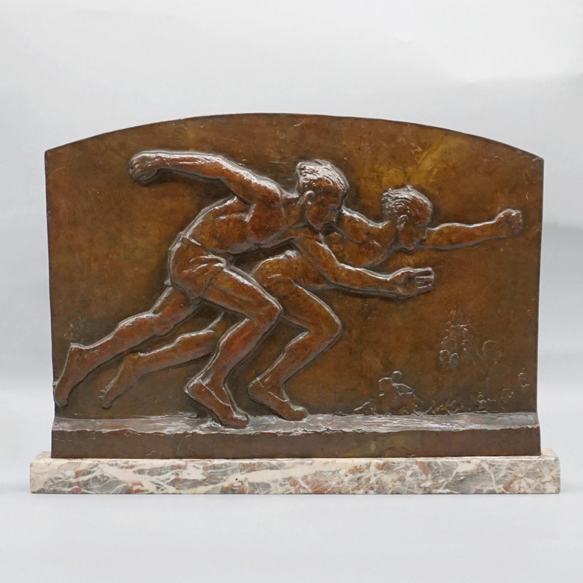 Une plaque de bronze d'Edouard Fraisse (1880 - 1956) représentant deux sprinteurs de 100 mètres franchissant la ligne d'arrivée. Signé E. Fraisse en bas à gauche du bronze. Le tout repose sur un socle en marbre d'origine. 
