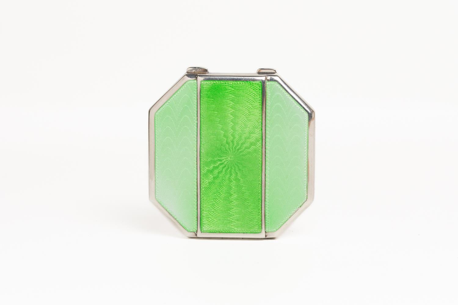 This fine and rare Art Deco green pale guilloche enamel compact was made in Birmingham 1934 and bears the marks of Mappin & Webb. This hexagonal form compact is decorated with a sunburst design, made in a beautiful pale green coloured enamel with a