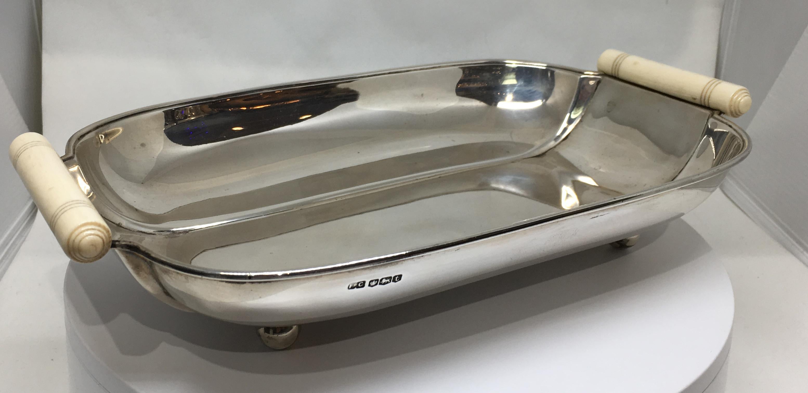 A gorgeous Art Deco sterling silver and carved bone tray / fruit bowl on four silver ball feet.

Dated for Sheffield 1936 and in superb condition.

The tray measures 10 5/8 inches wide, 6 1/2 inches deep and 2 1/2 inches high.