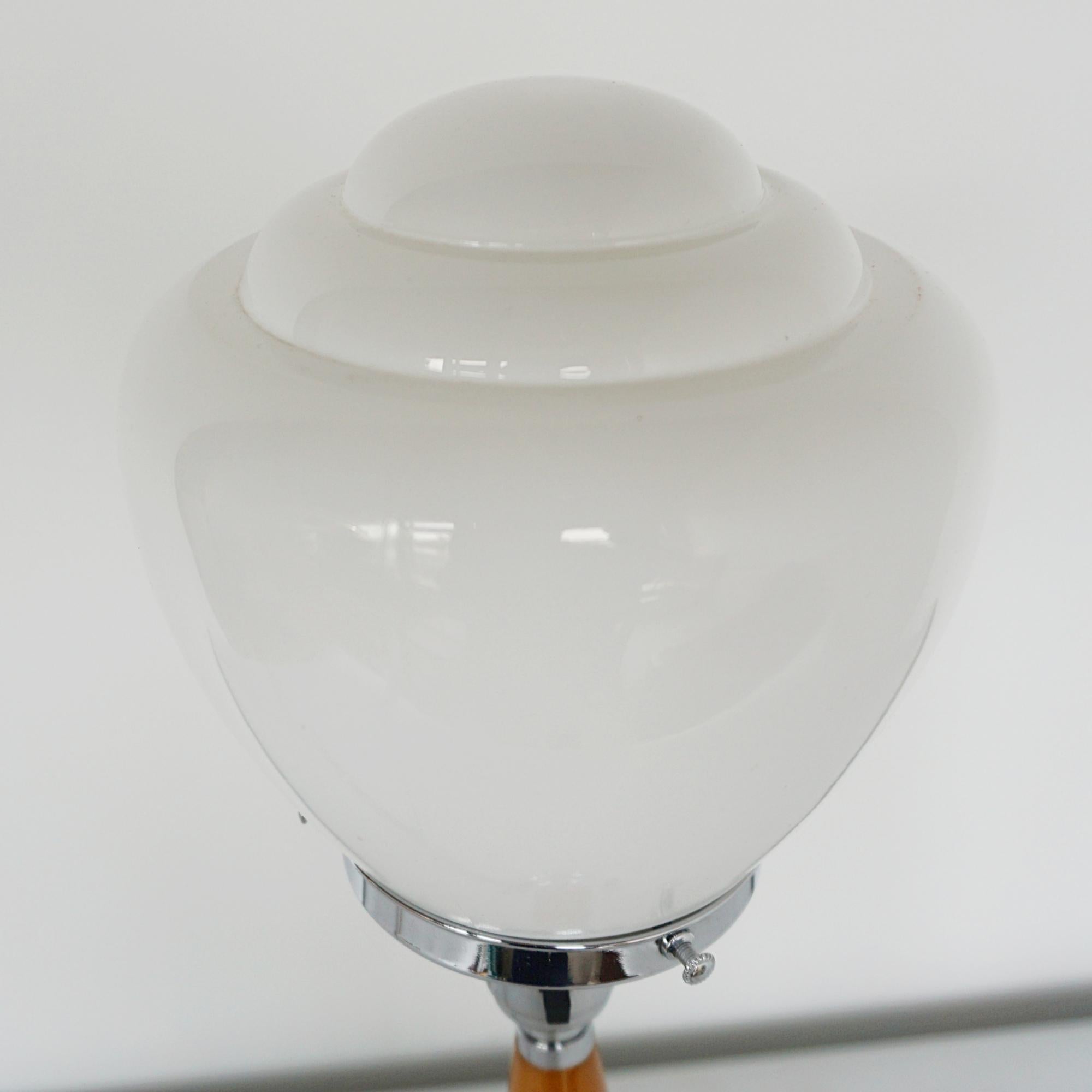 An Art Deco style table lamp. Tapered bakelite amber stem with a white stepped glass globe shade.

Dimensions: H 44cm D 13cm

Origin: English

Item Number: J346

All of our lighting is fully refurbished, re-wired, and re-chromed with some