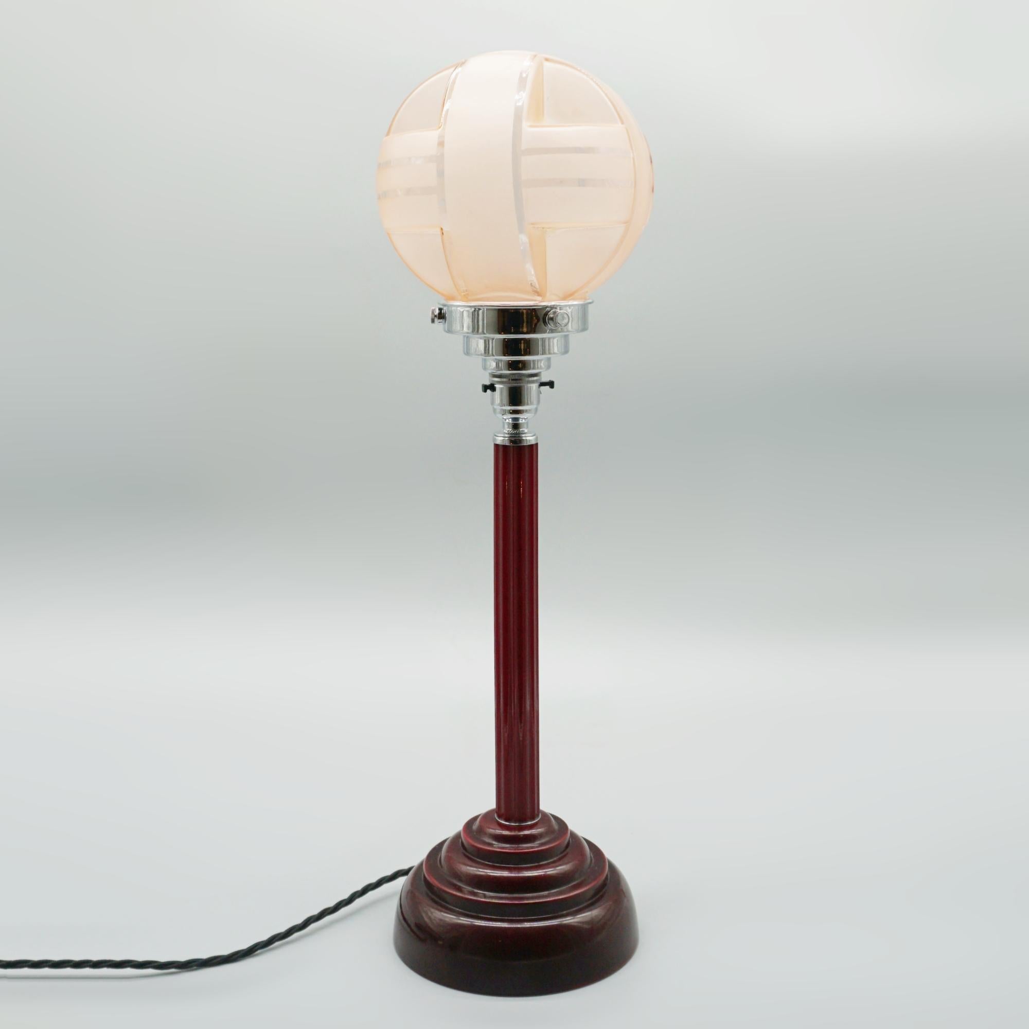 An Art Deco style table lamp. Maroon bakelite base with a maroon catalin stem and a blush glass globe shade.

Dimensions: H 54cm D 15cm

Origin: English

Item Number: J357

All of our lighting is fully refurbished, re-wired, and re-chromed with some