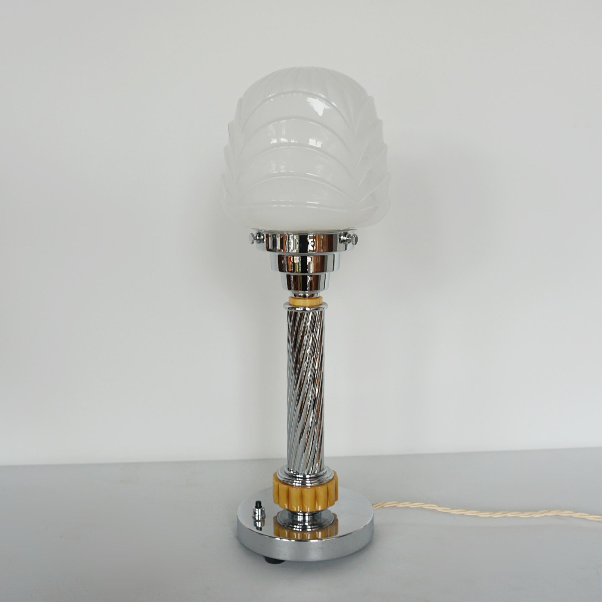 An Art Deco table lamp. Ribbed amber bakelite with spiralled chrome stem and a white ridge globe

H 42cm W 14cm

Origin: English

Item Number: J338

All of our lighting is fully refurbished, re-wired, and re-chromed with some replacement parts.