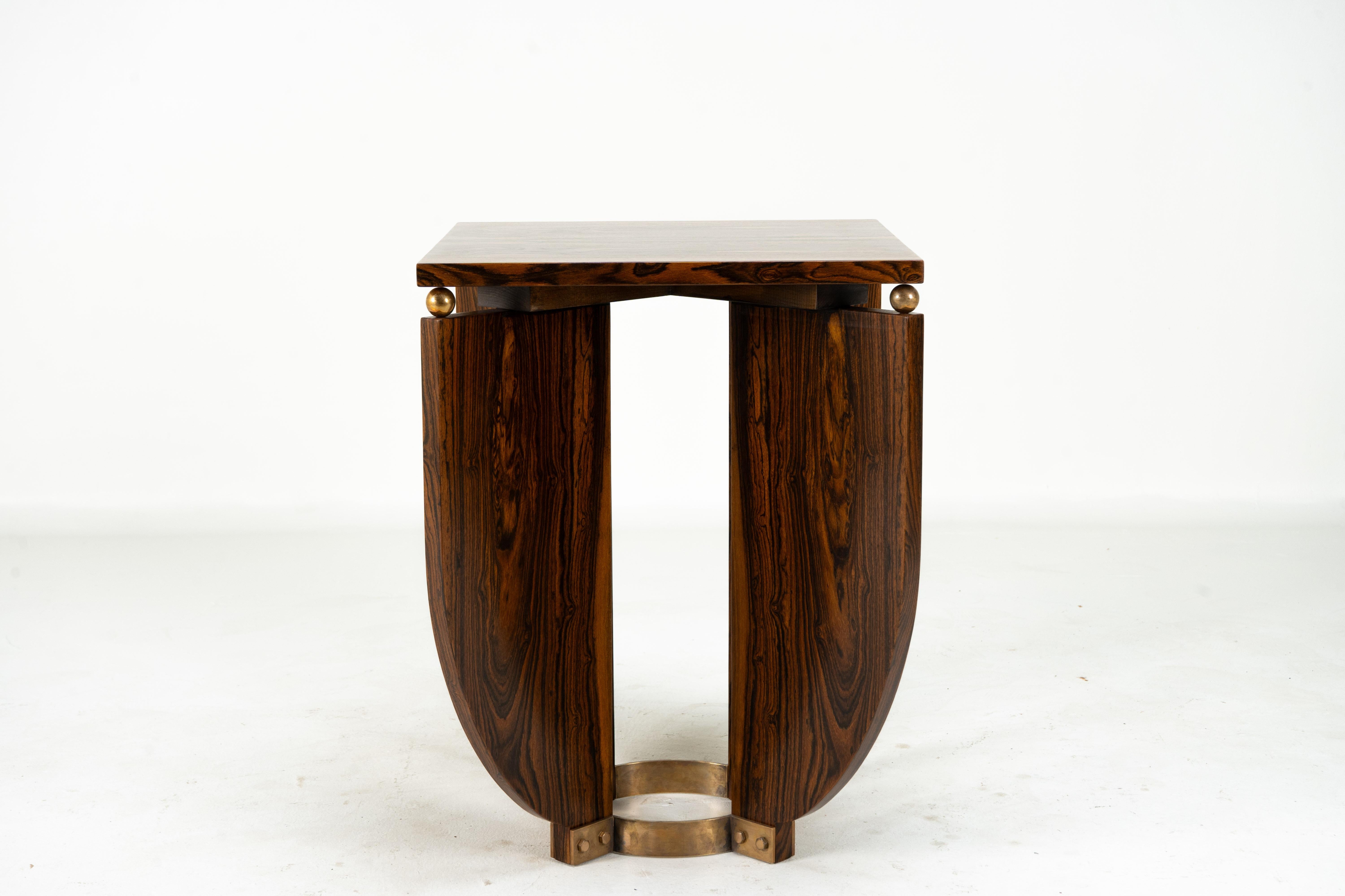 This very sleek and sophisticated end table is crafted from ziricote wood veneers and a solid brass base. Ziricote is an extremely dense medium-brown hardwood with a unique interlocking grain that can be polished to a high sheen. The table is a