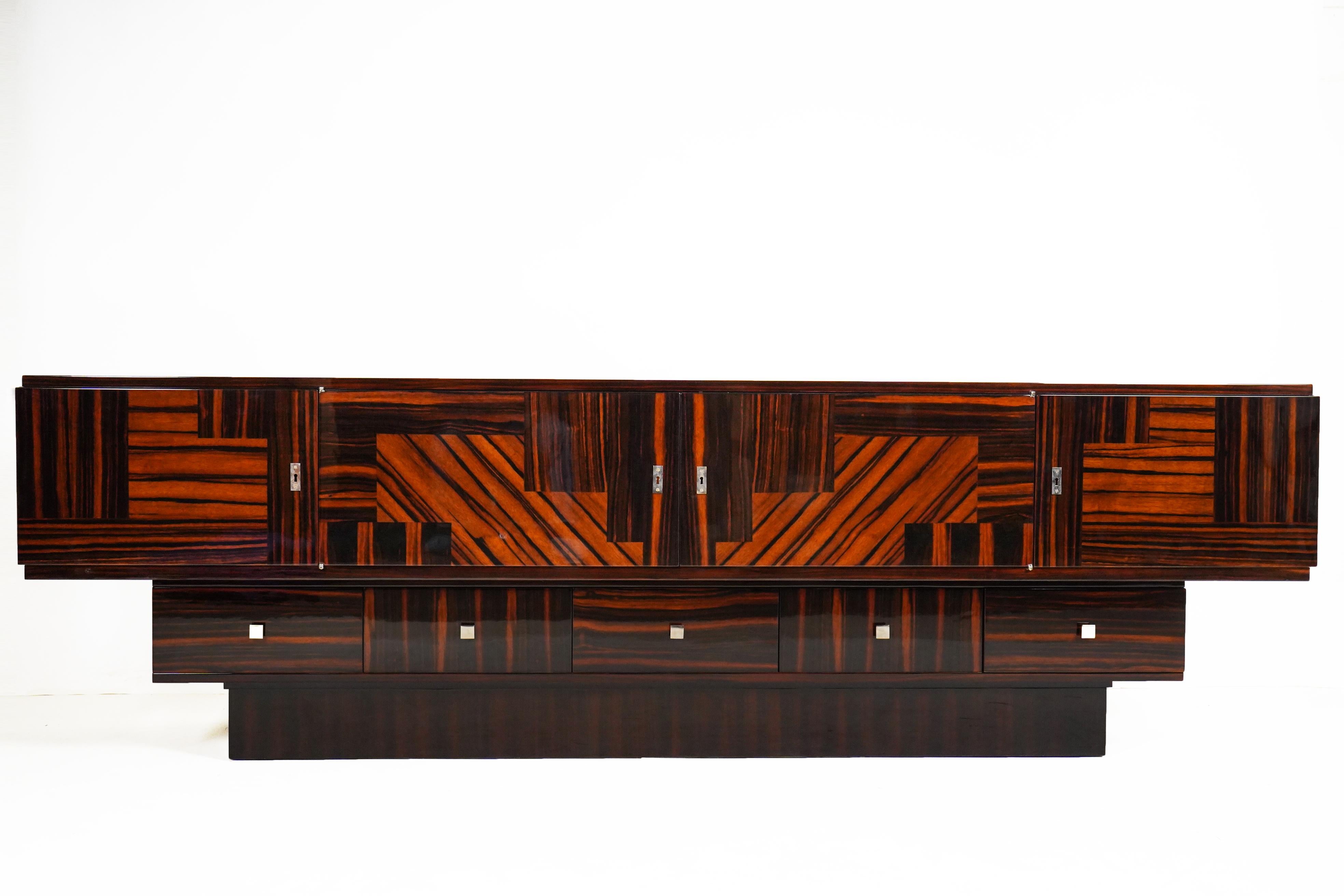 This large and sleek sideboard is made from five different kinds of Makassar ebony veneer. Makassar is an exotic hardwood prized for its hardness, durability and beautiful grain. It first became widely known during the Art Deco period, largely due