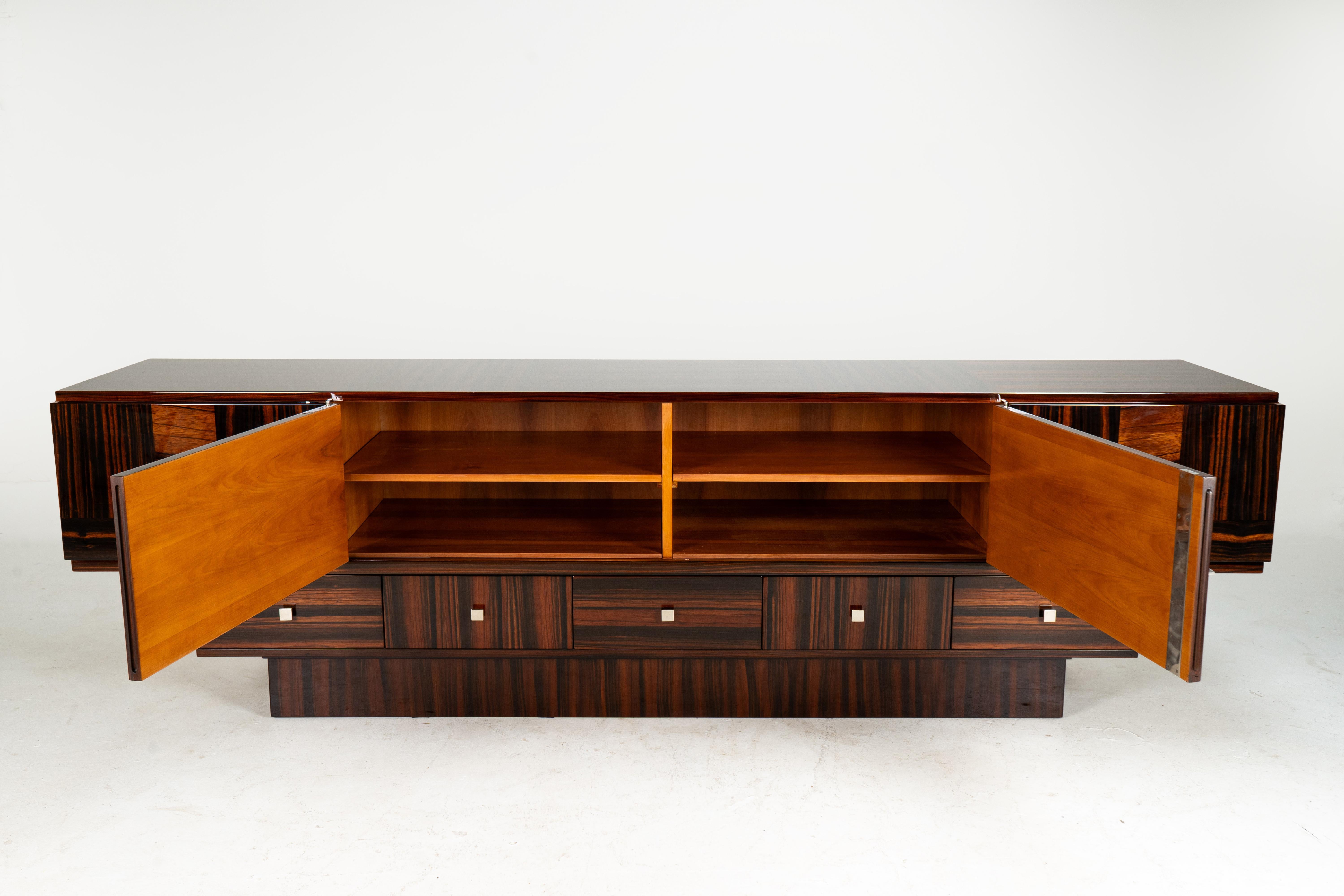 This large and sleek sideboard is made from five different kinds of Makassar ebony veneer. Makassar is an exotic hardwood prized for its hardness, durability, and beautiful grain. It first became widely known during the Art Deco period, largely due