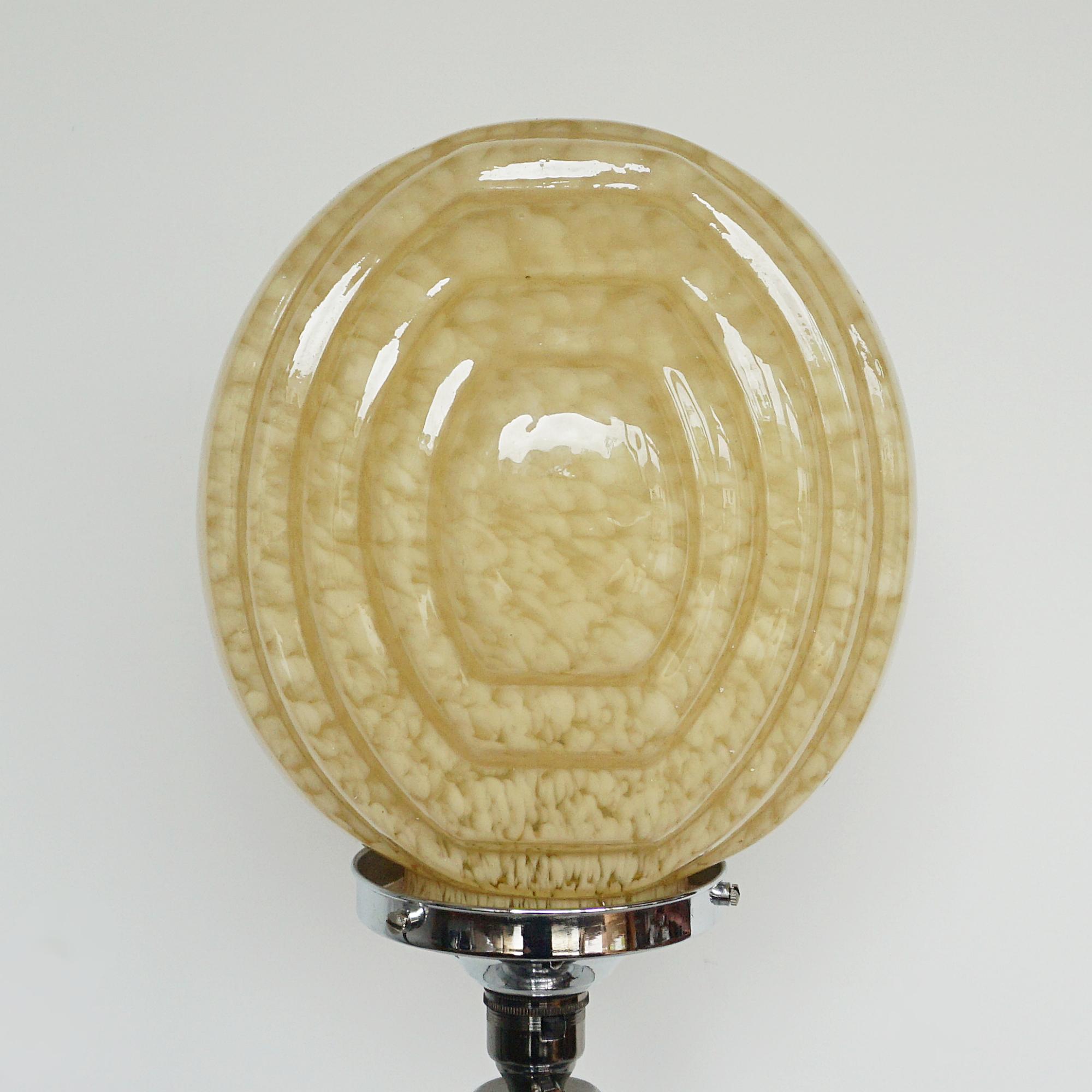 An Art Deco table lamp. Reeded bakelite stem with an impressive sized mottled glass shade, set over a circular chromed metal stepped base. 

All of our lighting is fully refurbished, re-wired, and re-chromed with some replacement parts.