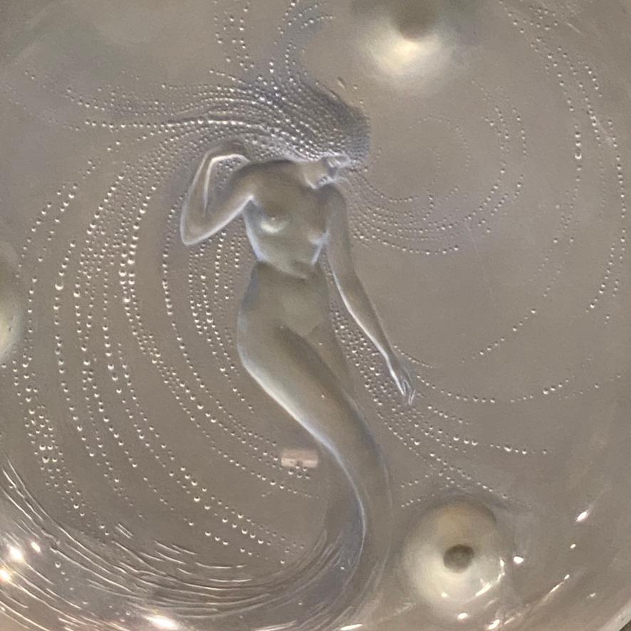 The Trépied Sirène is probably R.Lalique 's most accomplished bowl as for the shape, as for the subject.

 The Mermaids have been fascinating creatures since ancien times.

The Art Deco period took part in the illustrating their