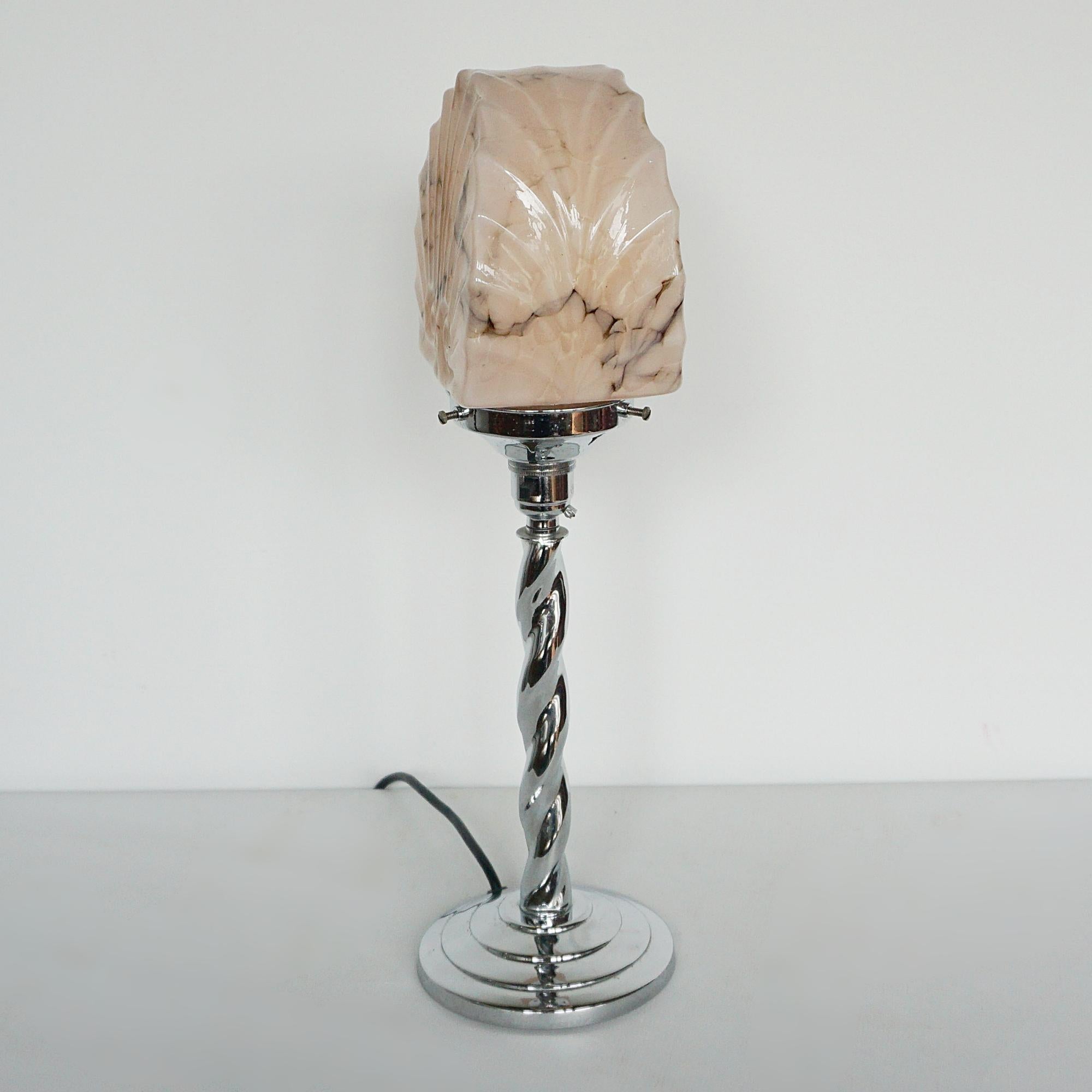 An Art Deco table lamp. Twisted chromed metal stem with a marbled pink clam shade. 