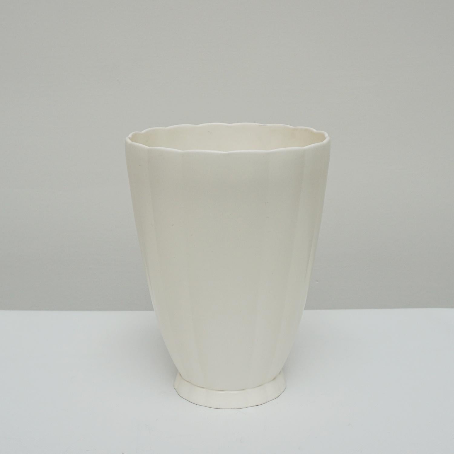 An Art Deco cream earthenware vase. Designed by K.Murray for Wedgwood. Stamped to base.

Origin: English

Date: Circa 1935