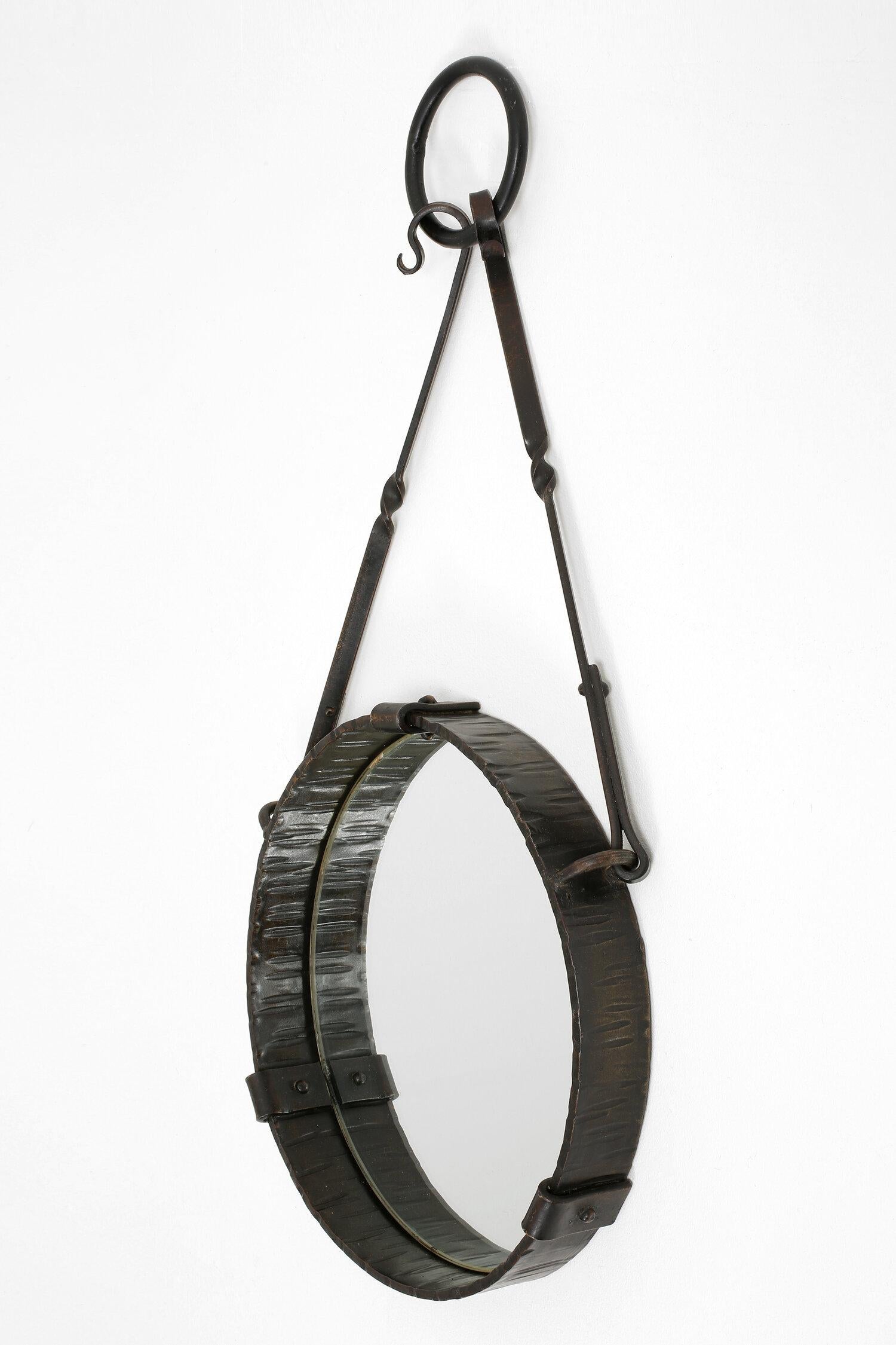 A wrought iron suspended circular mirror
France, circa 1940.