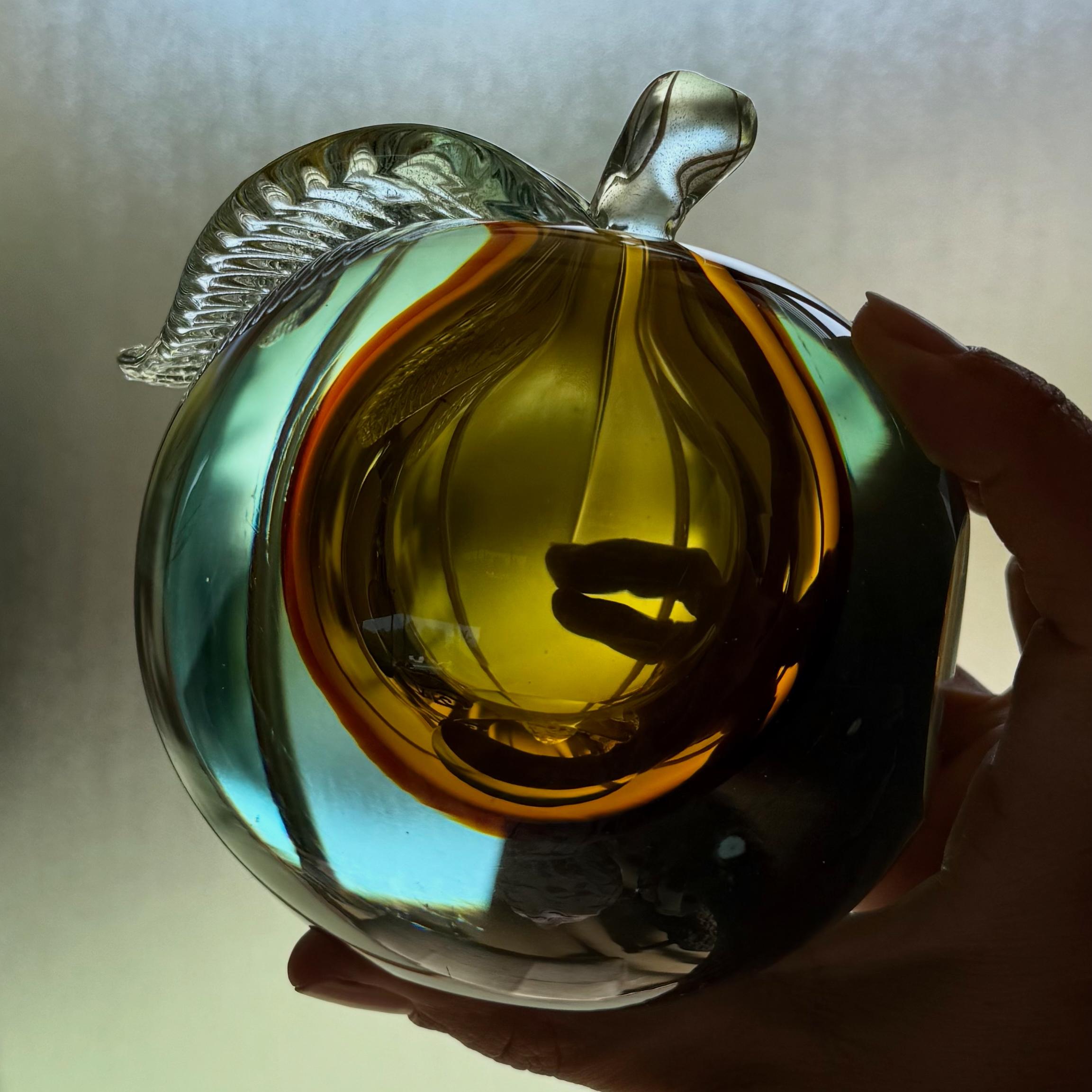 Una splendida scultura o fermacarte in vetro artistico raffigurante una mela, attribuita a Livio Seguso per Murano, Italia, XX secolo. Toni di acqua e ambra a doppia parete e foglia infusa con polvere d'oro. 